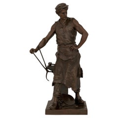 Una statua francese in bronzo patinato raffigurante un fabbro, firmata Emile Louis Picault