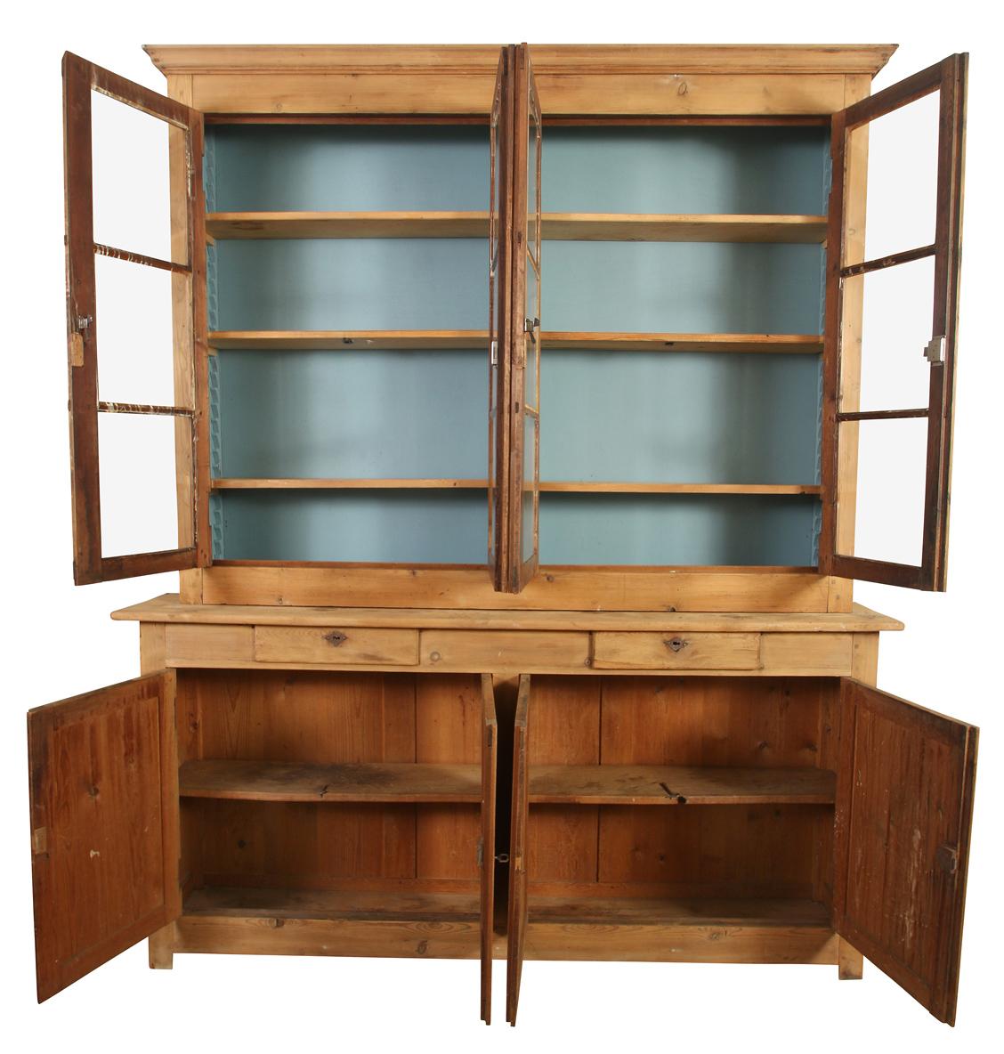 A large French pine breakfront cabinet with glass doors on upper cabinet over storage cabinets on base.  The top interior is painted blue, and is a lovely showcase for books, plates or decorative objects.  This unique piece can work in a kitchen,