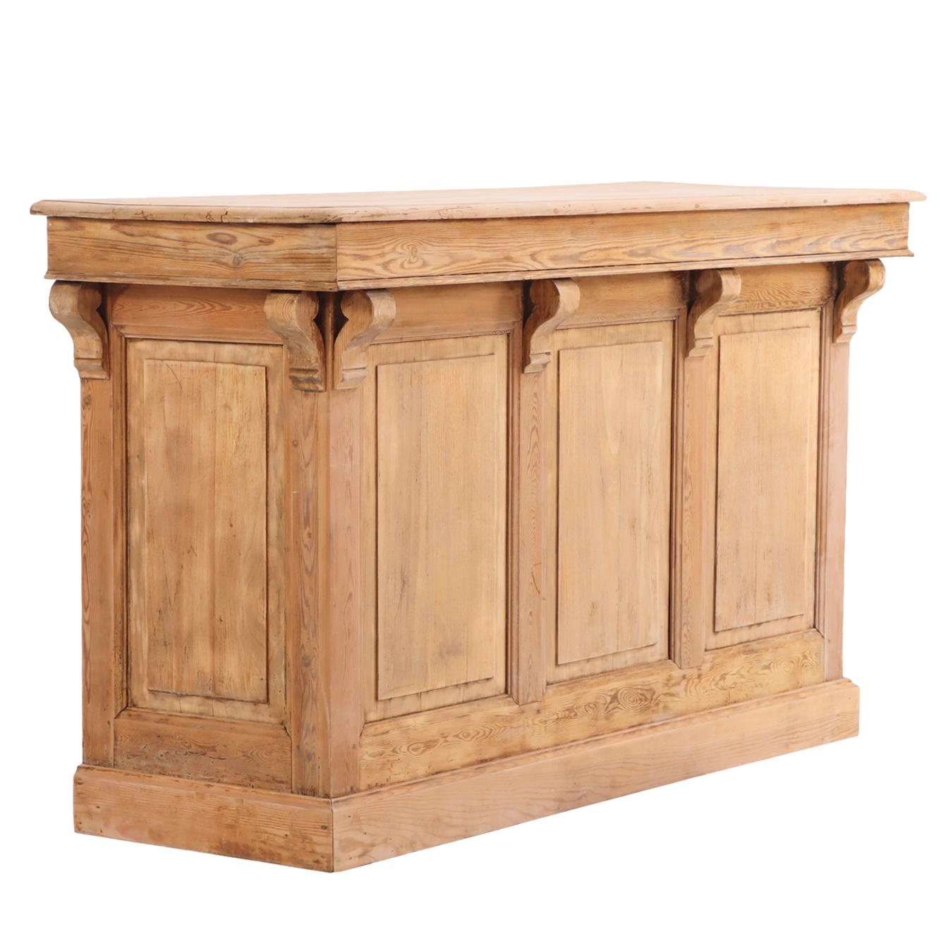 A handsome French pine bar counter, circa 1880, featuring columned details along the front and sides. The open back is fitted with a single small drawer above open shelving, offering practical storage and display space.

Perfect for use as a bar,