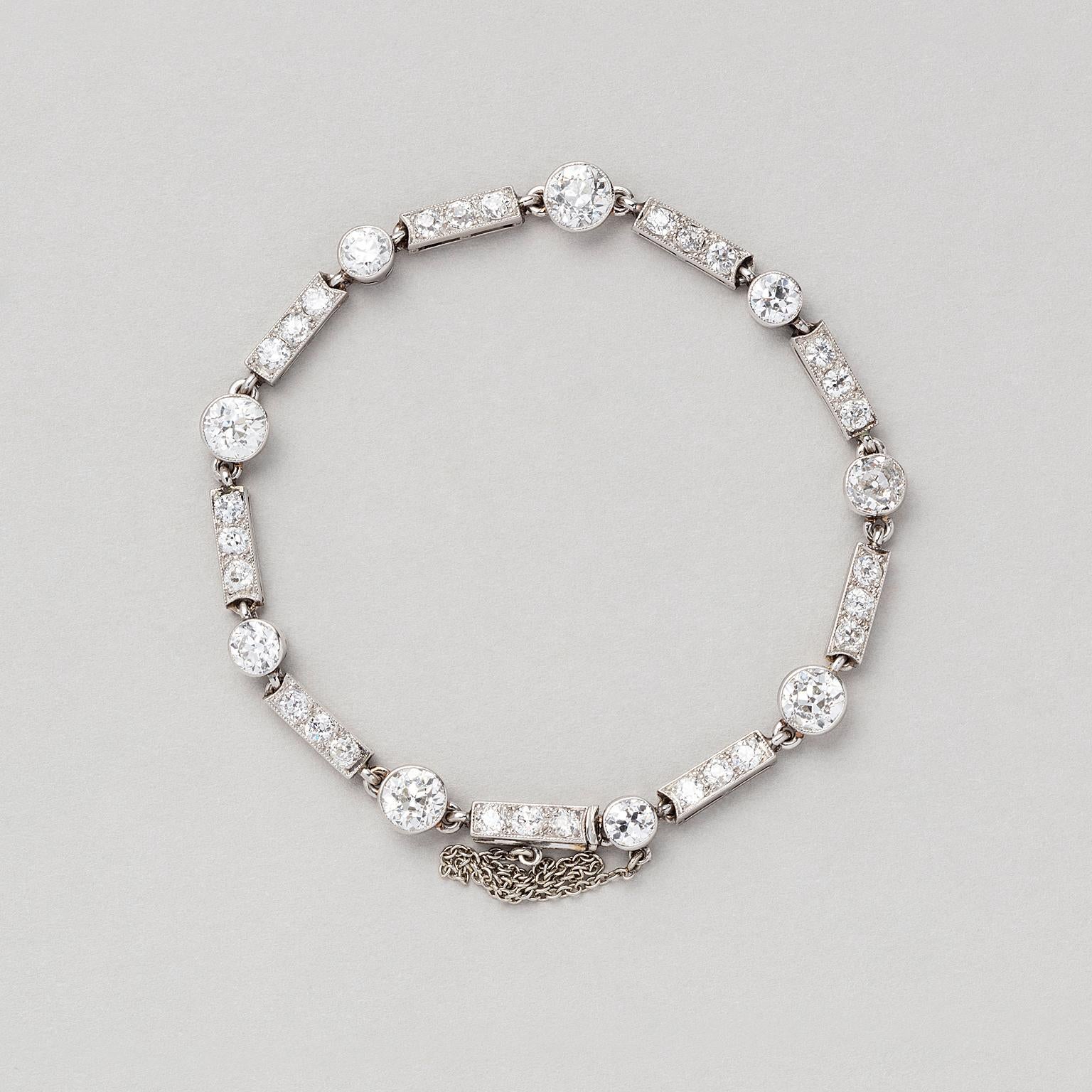 A platinum Art Deco bracelet with single bezel set old cut diamonds alternated with barettes set with old cut diamonds circa 6 carat in total, H - Si), France circa 1930.

weight: 14.51 grams
length: 17.5-18 cm

