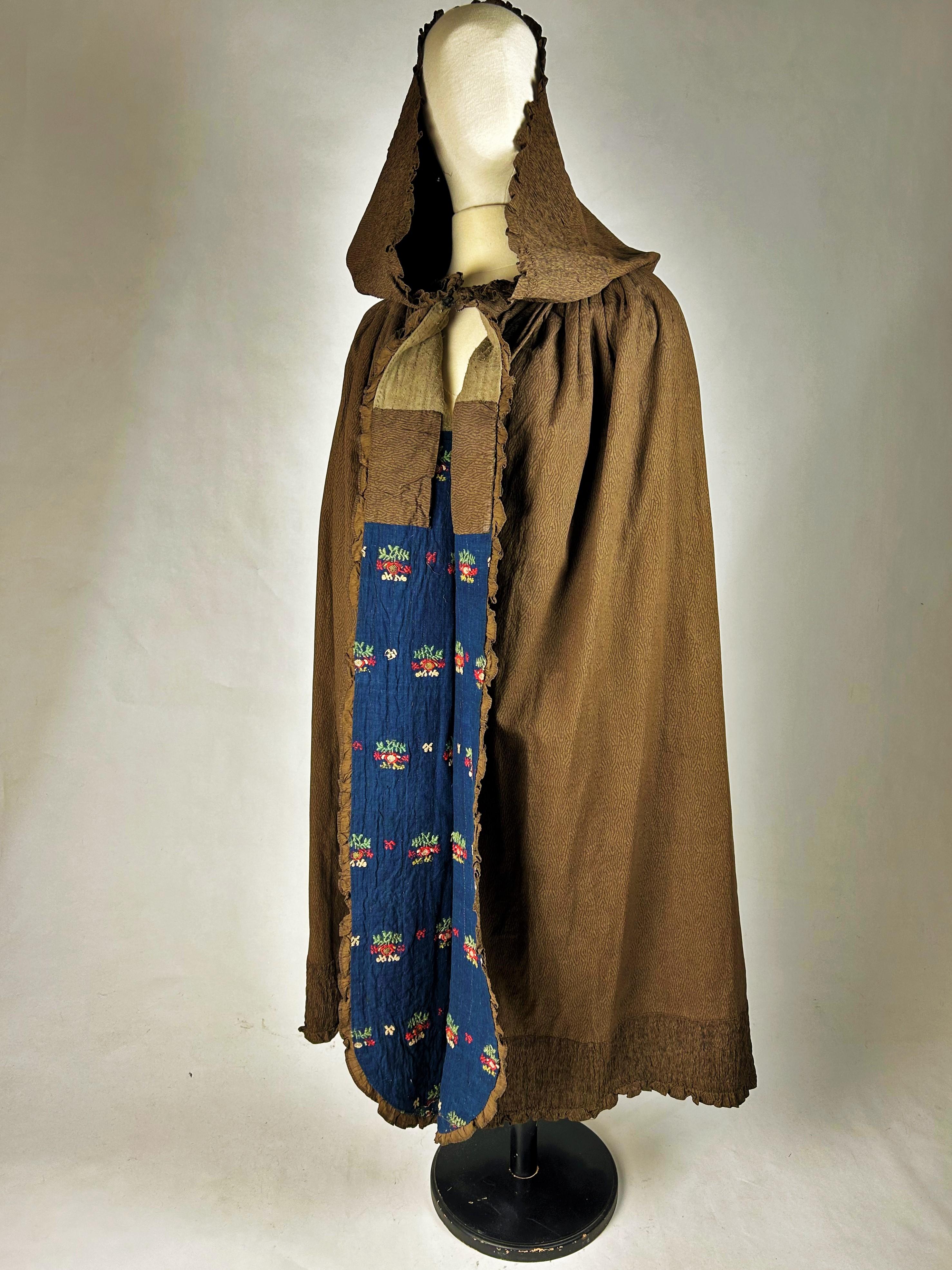 First third of the 19th century
Provence
Beautiful Polonaise Cape or hooded cloak in Puce printed cotton imitating chinés à la branche. It is lined with an astonishing reused 18th century Indigo cambric. Printed on cotton using a roller or copper
