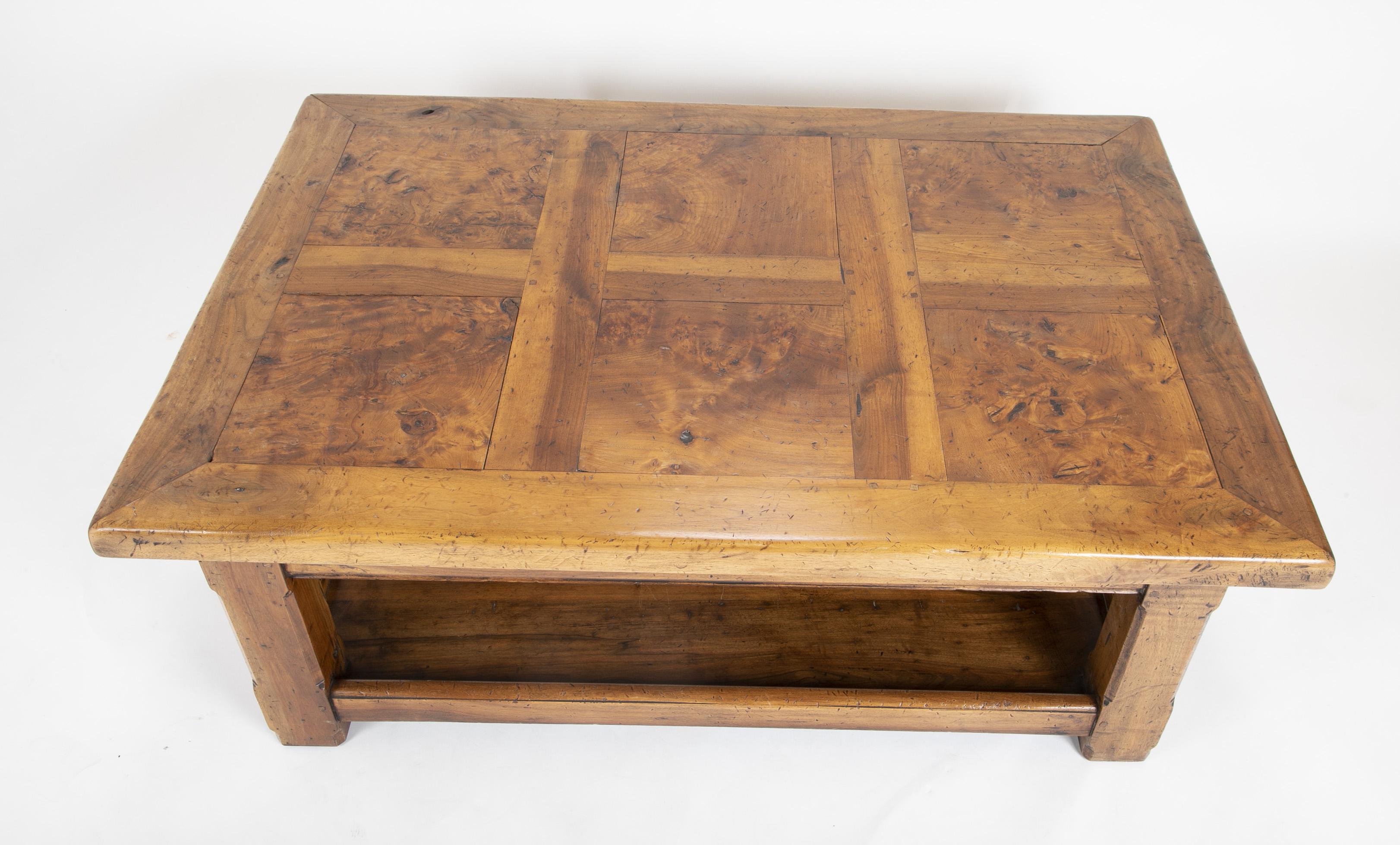A rustic French coffee table, circa 1900. Walnut frame with burled elm panels.