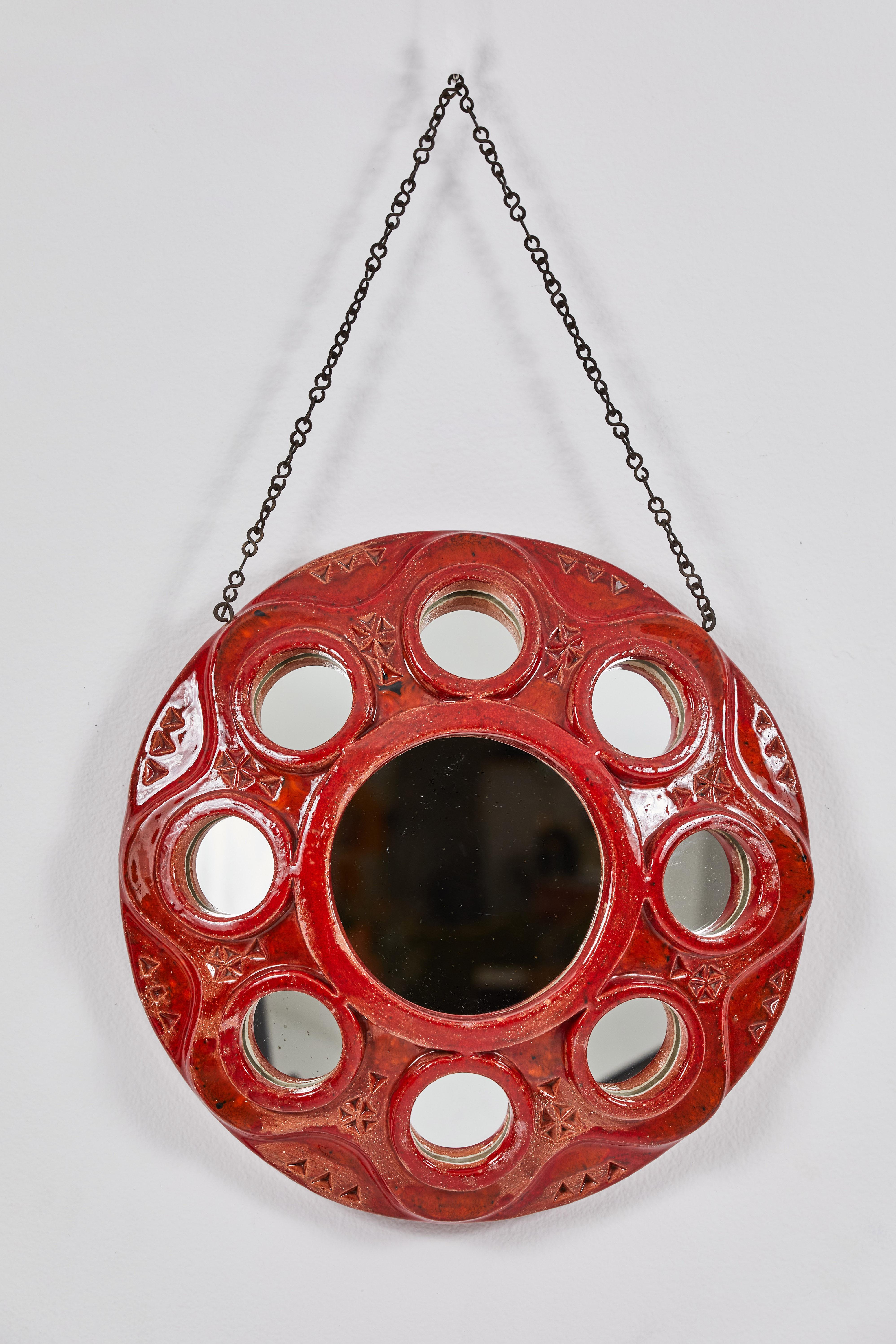 This is a very unique French Clay mirror in a striking red glaze. It features one center mirror measuring 7