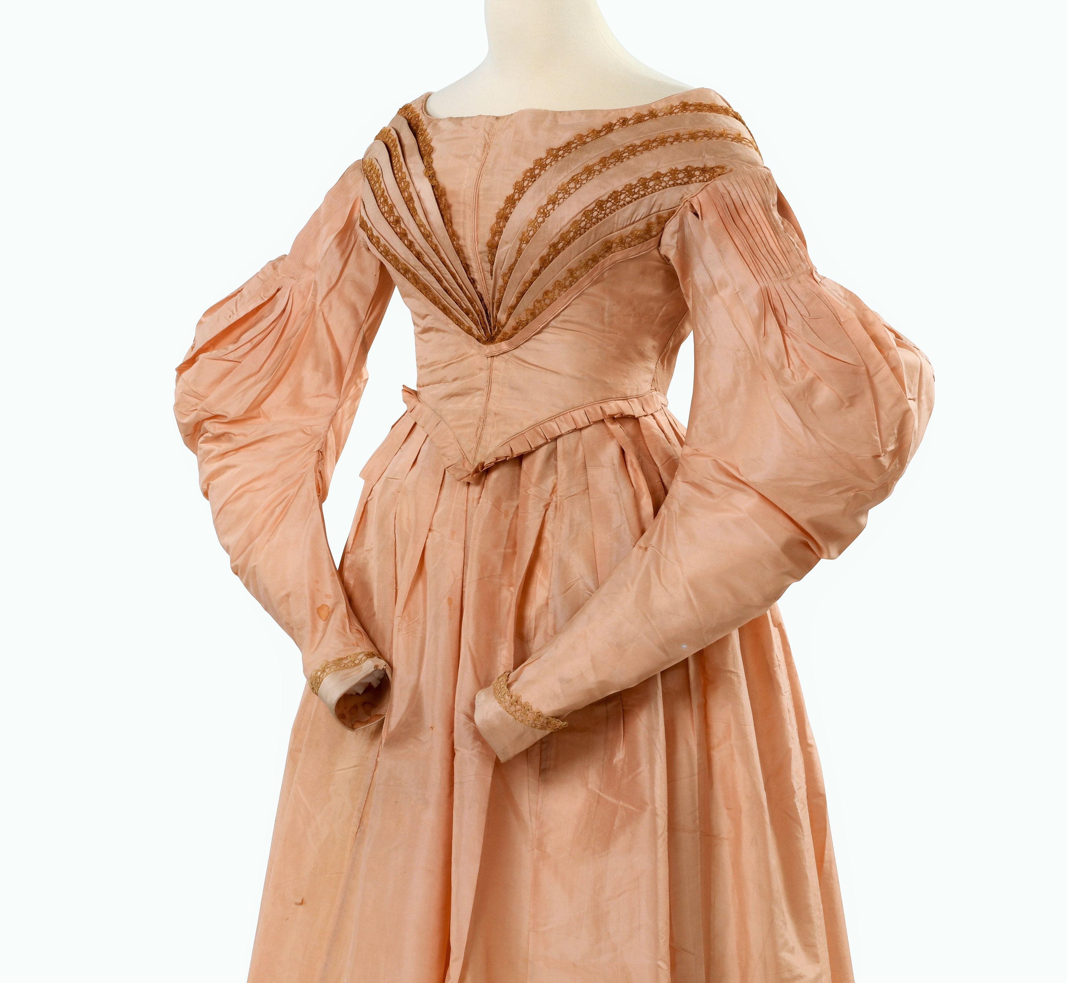 Circa 1835-1840
France

Romantic period dress in pale pink Florence taffeta dating from the reign of Louis-Philippe. Dress lined with cream cotton, with a separate bodice effect, pointed in front and closed by hooks in the back with a V-shaped cut. 