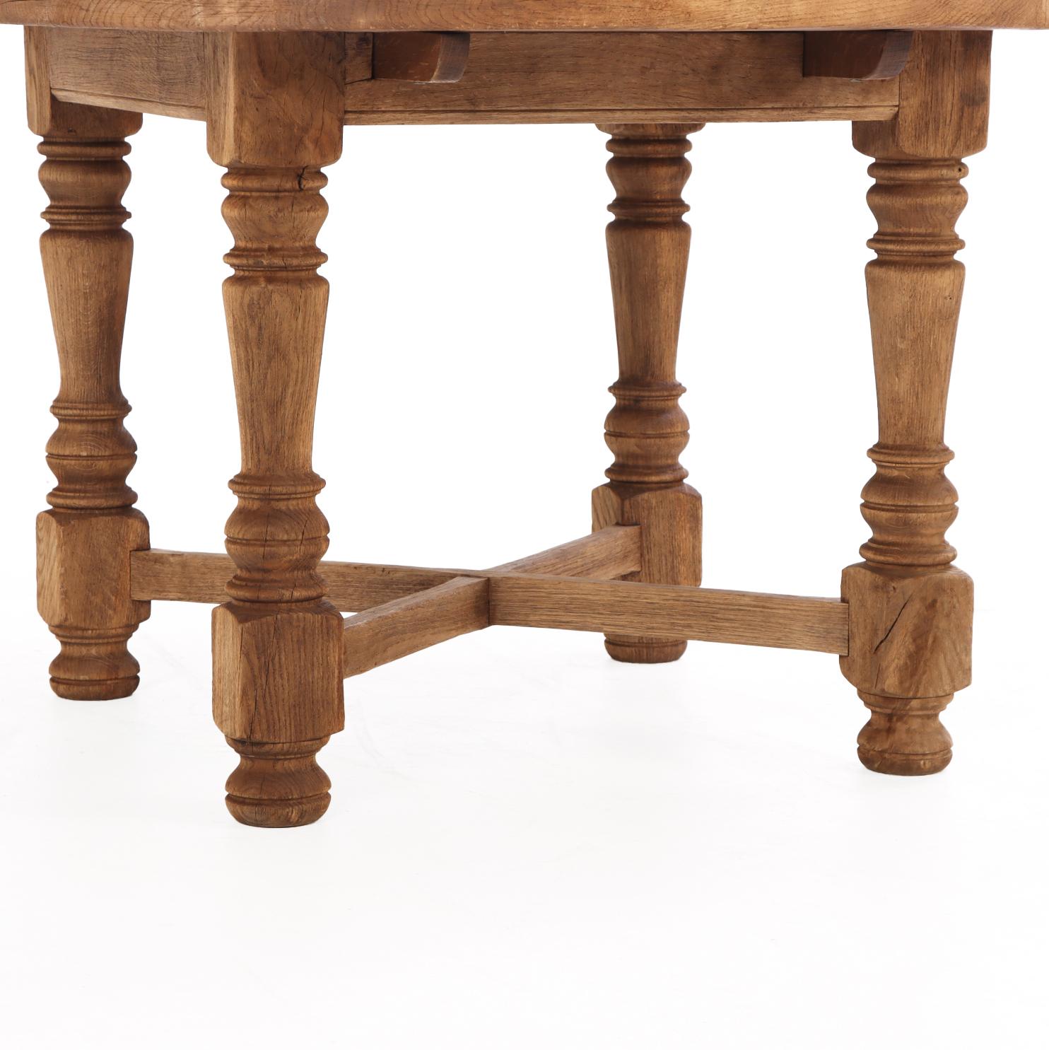 Cette table de ferme en chêne français rond, belle et bien proportionnée, met en valeur l'artisanat rustique et le caractère usé par le temps. Le plateau en chêne massif s'ouvre sur des glissières d'extension pour accueillir des feuilles