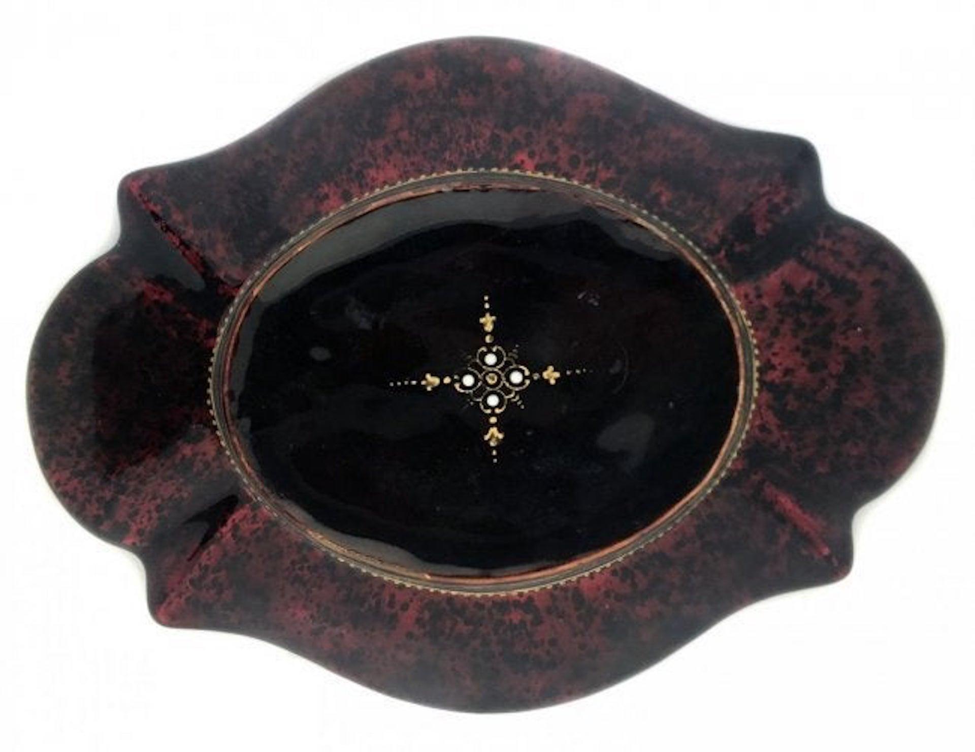 A French ruby-red glass and enamel card tray
late 19th or early 20th century
painted with a reclining goddess, on a faux red tortoiseshell ground
Measures: Length 7.25 in. (18.41 cm.) long, width 5.37 in. (13.65 cm.)
      