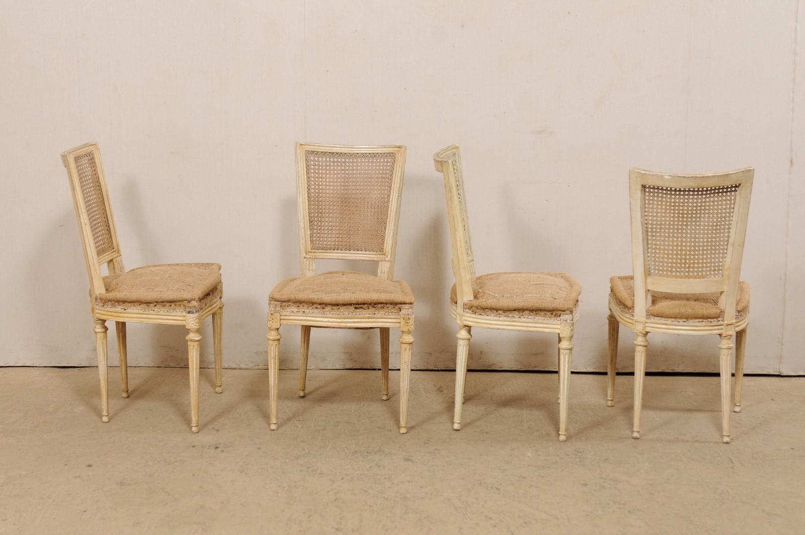 A set of six French Louis XVI style cane back chairs from the early 20th century. This antique set of side chairs from France each features a squared back with hand-woven cane framed within a simple and clean molded trim about the crest rail and