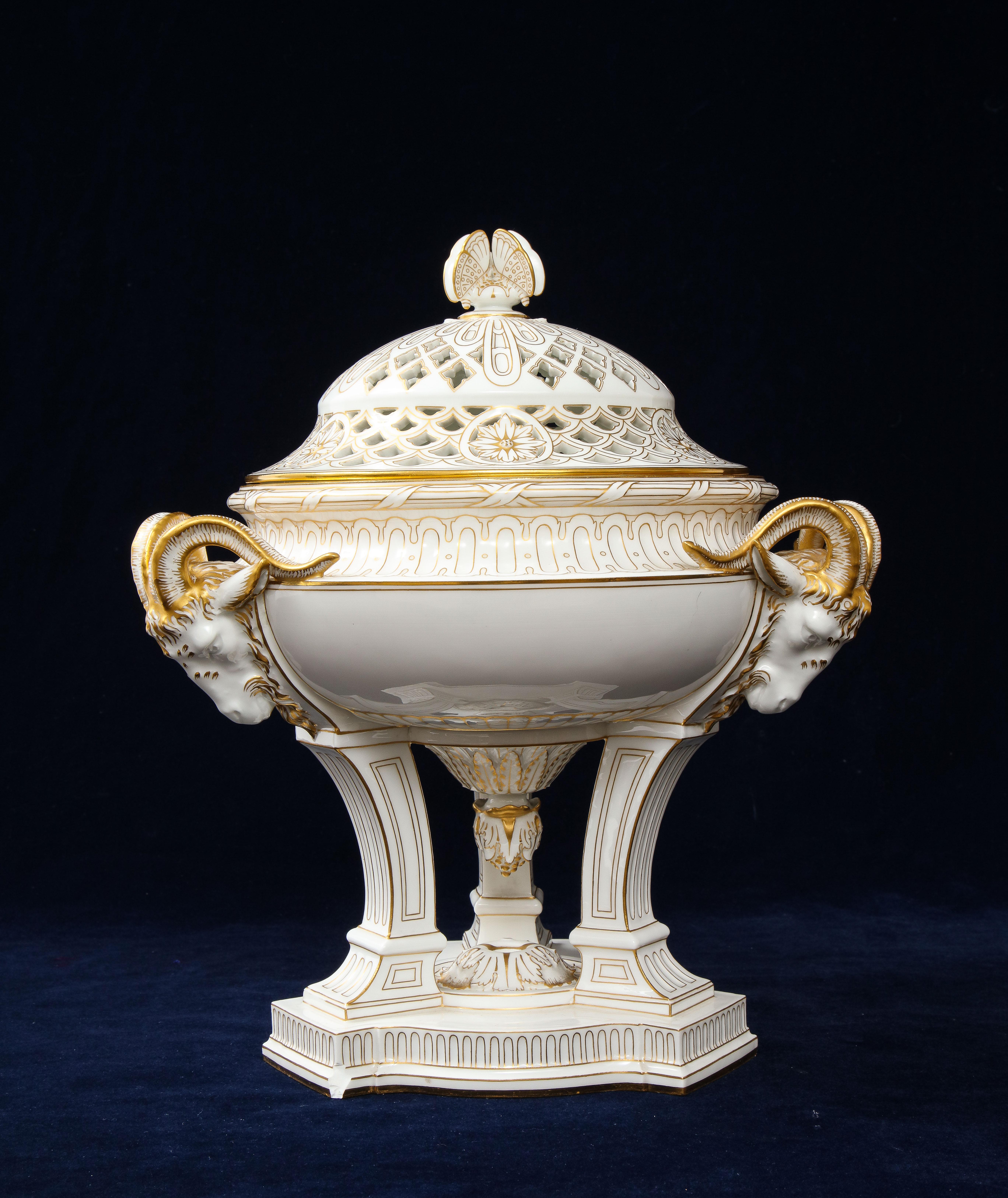 A French Sevres Porcelain Triple Rams Head Potpourri Covered Centerpiece.  Notably, the centerpiece is crowned with three delicate butterflies gracefully perch atop the lid, positioned upon a geometrically stylized gilt trimmed flower that rests
