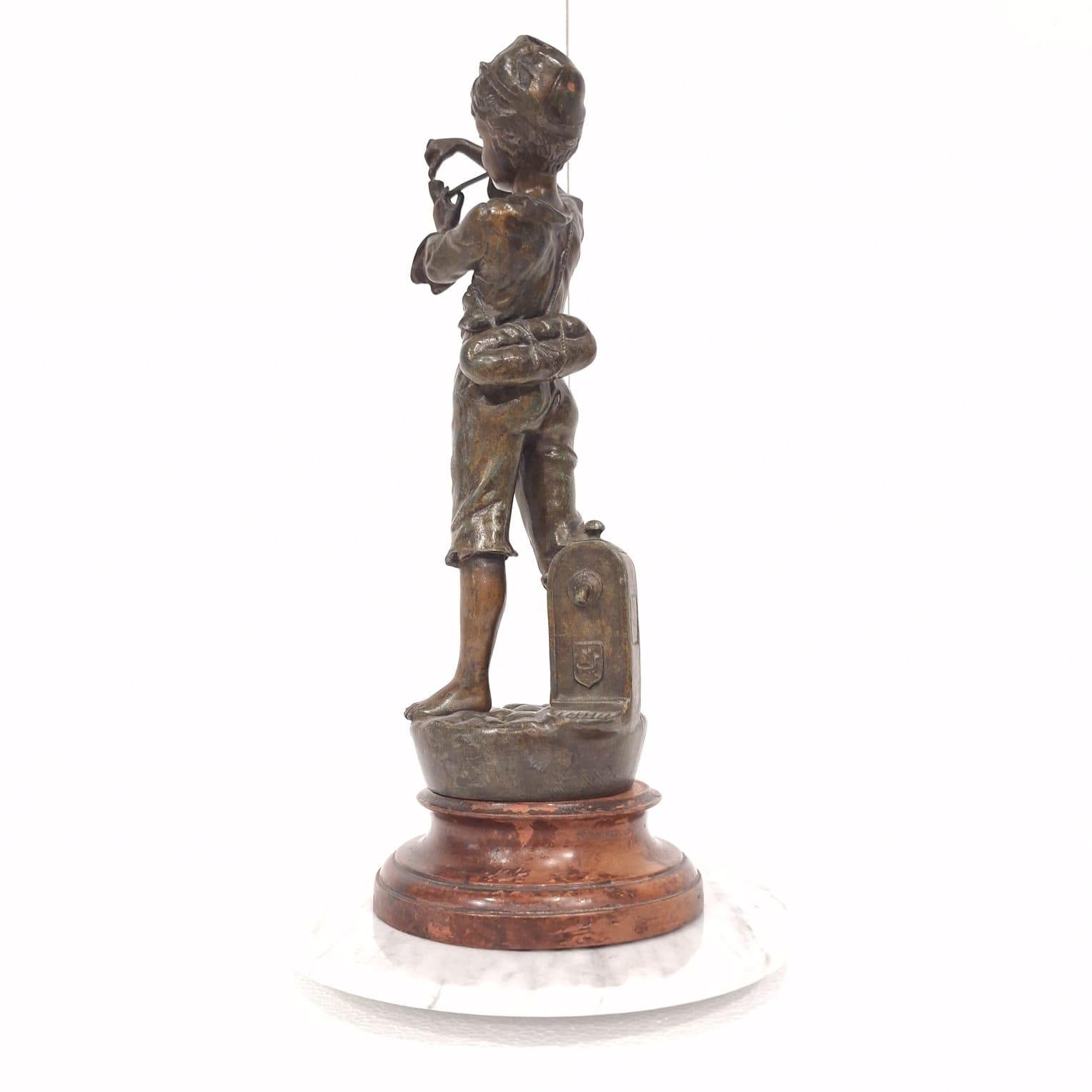 Statua francese in ghisa raffigurante un ragazzo che accende la pipa in vendita 1