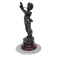 Statua francese in ghisa raffigurante un ragazzo che accende la pipa