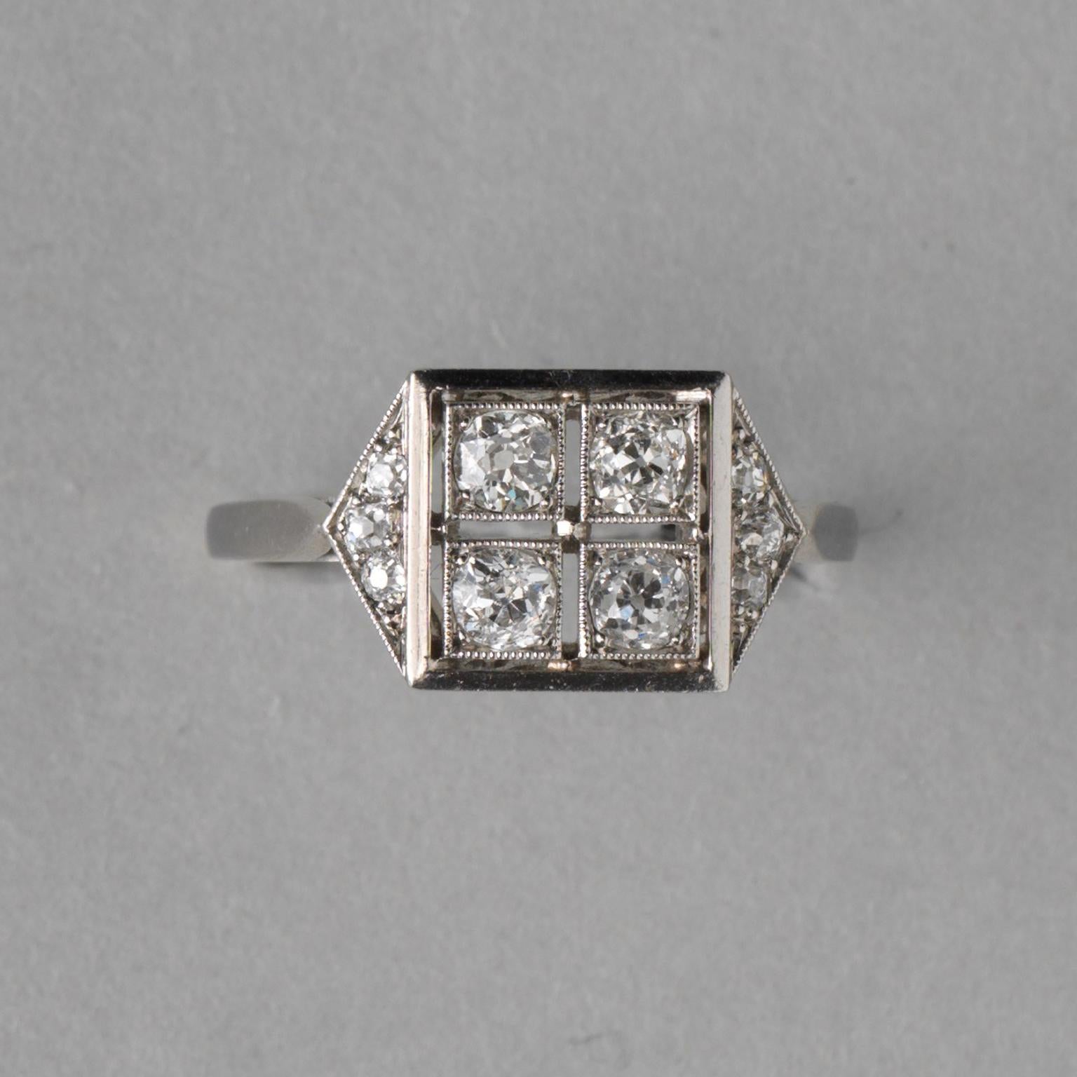 A platinum ring set with four old cut diamonds in a square each set in a mille griffe border with on each side a sloped triangle set with three diamonds (app. 0.7 carat), with a beautifully florally open worked gallery, numbered: 27500, France,