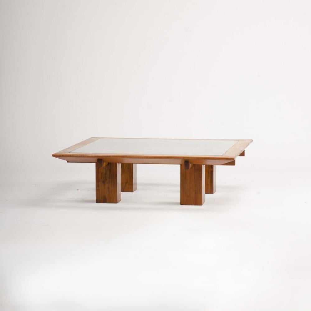 Une belle et inhabituelle grande table basse en sycomore français avec un plateau en verre et reposant sur quatre bases de piédestaux carrés.