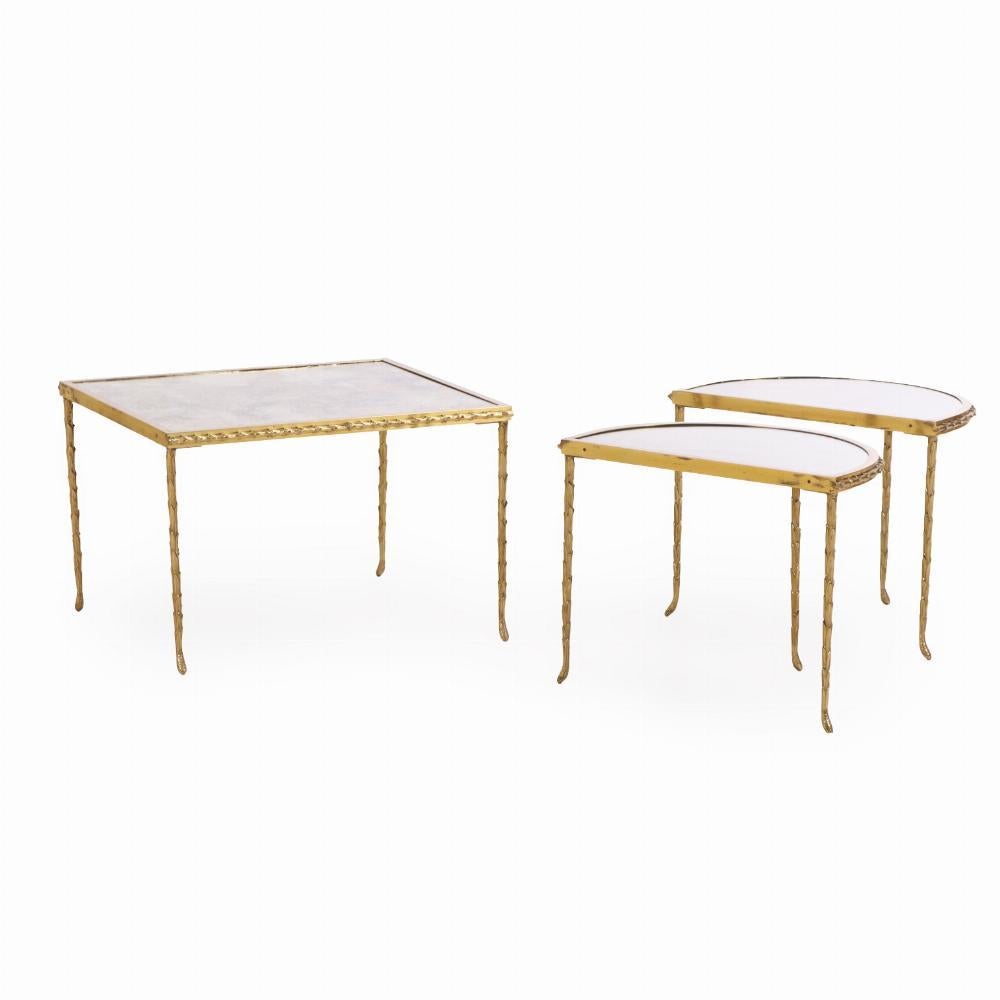 An elegant and versatile coffee table attributed to Maison Baguès, France. Crafted in finely cast bronze with a warm, gold patina, the foliate design reflects the understated glamour of mid-century French design. The trio - two D shaped and one