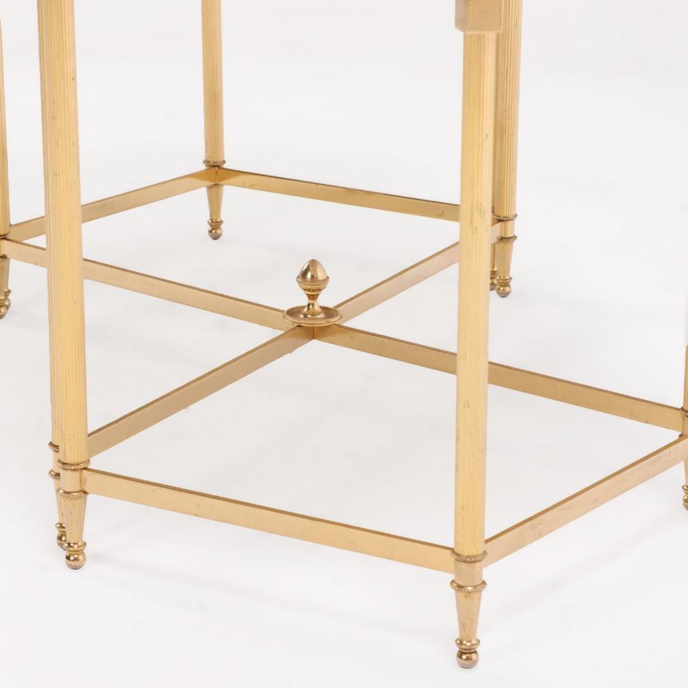 A striking French coffee table featuring a sculptural brass-plated metal base composed of three interlocking elements. Each section supports a top inset with richly veined onyx, creating a luxurious contrast between the warm metallic finish and the