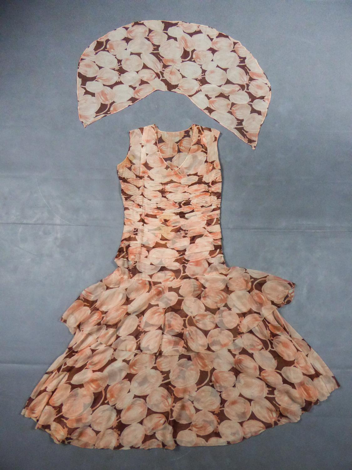 Um 1930/1940
Frankreich

Anonymer Haute Couture-Schal und Kleid aus Seidenkrepp, bedruckt mit Früchten in Rosa-, Orange- und Brauntönen, aus den Jahren 1930/1940. Röhrenförmiger, ärmelloser Schnitt, typisch für die 1930er Jahre, mit Schrägschnitt in