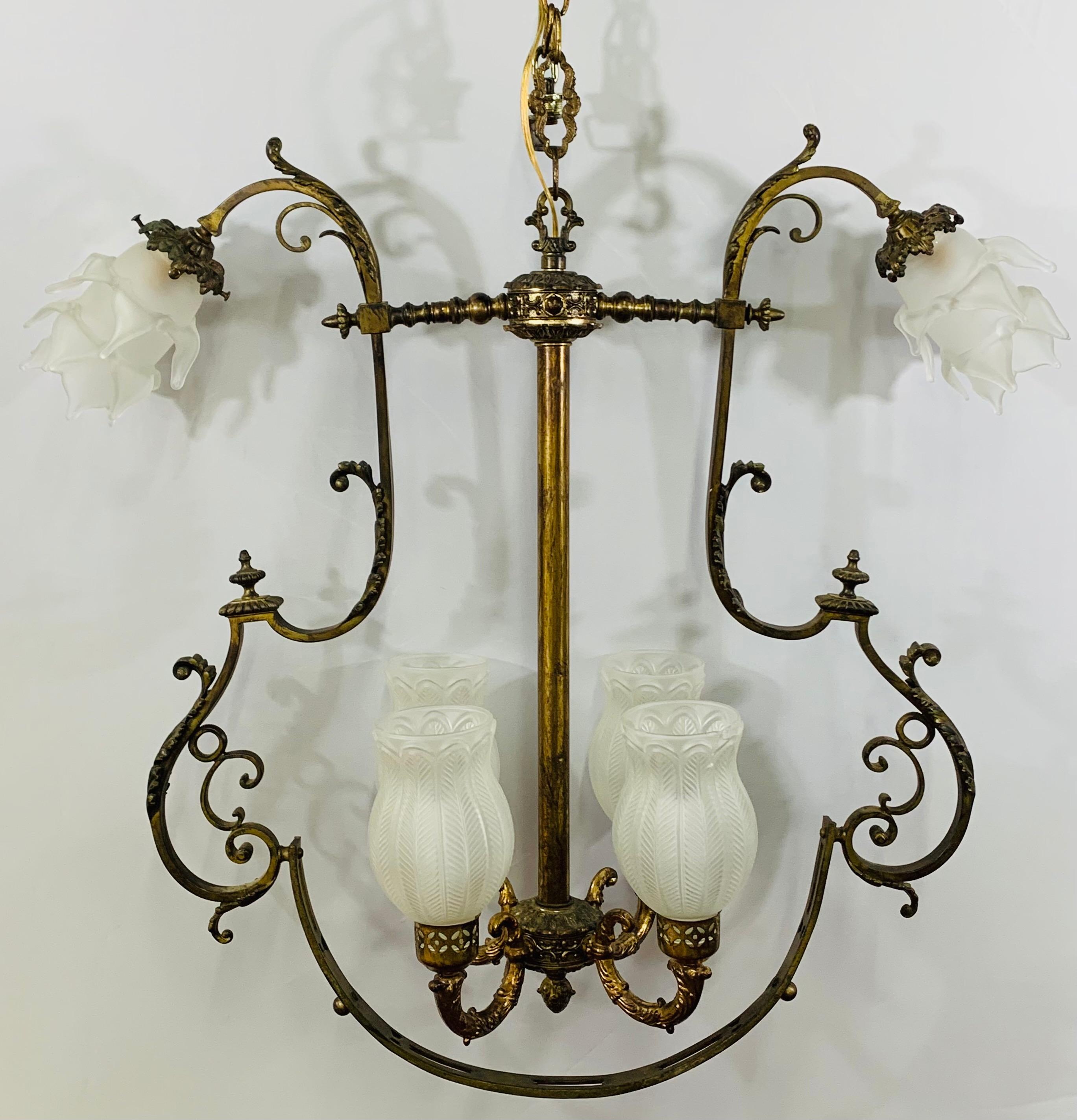An exquisite early 20th century French Victorian Gasolier converted 6-light chandelier. The elegant brass chandelier features 4 candelabra lights with original etched globe shades in the center and two arms ending with one candelabra light on each