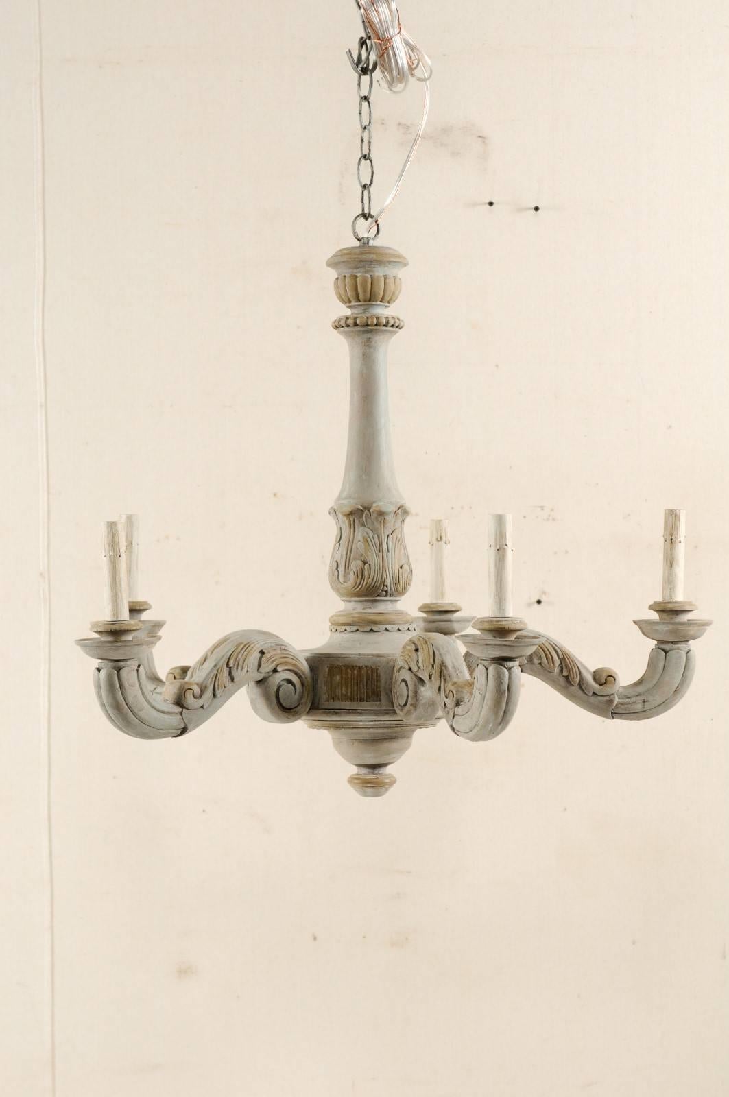 A French carved and painted wood five-light vintage chandelier. This lovely French chandelier from the mid-20th century features a carved central column adorn with dotted trim and acanthus leaf wraps. There are recessed fluted panels on the more