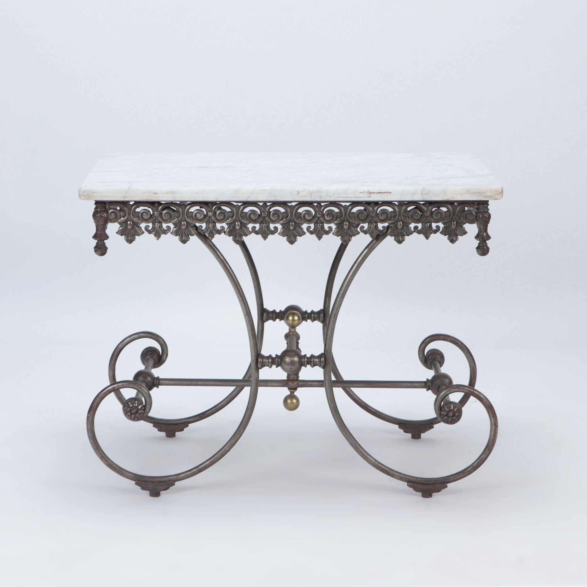 A French vintage cast iron and white marble bakers table. The table features a decorative Fleur de Lis motif and is branded by maker in top rail. Paris, late 19th C. Part of motif missing in the back.