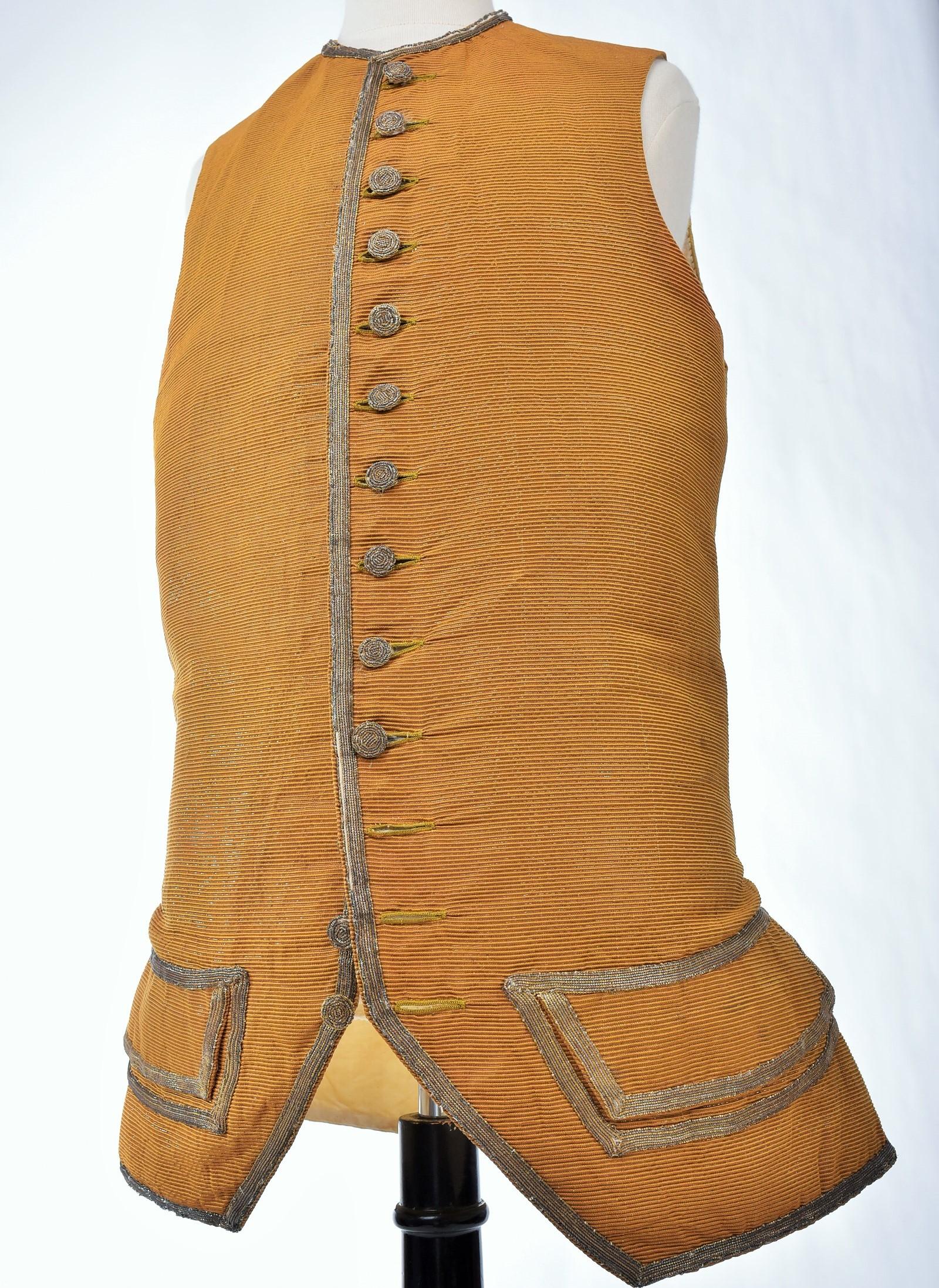 Circa 1760
Francia

Un raro gilet da gentiluomo in seta lamé dorata e scanalata, chiamata faille francese, di colore cacca d'oca e risalente al periodo Luigi XV. Body a vita piccola con baschine lunghe e due tasche. Completo dei suoi bottoni