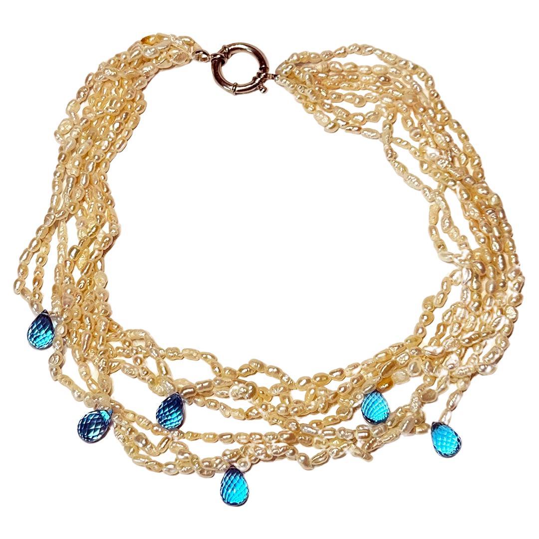 A Freshwater Keishi Pearl Necklace with 36.9 Carats, 6 Topaz Briolettes, strung on 7 strands of freshwater Keishi Pearls.  This necklace has a silver hoop clasp that makes it easy to fasten and unfasten.

Originally from San Diego, California, Kary