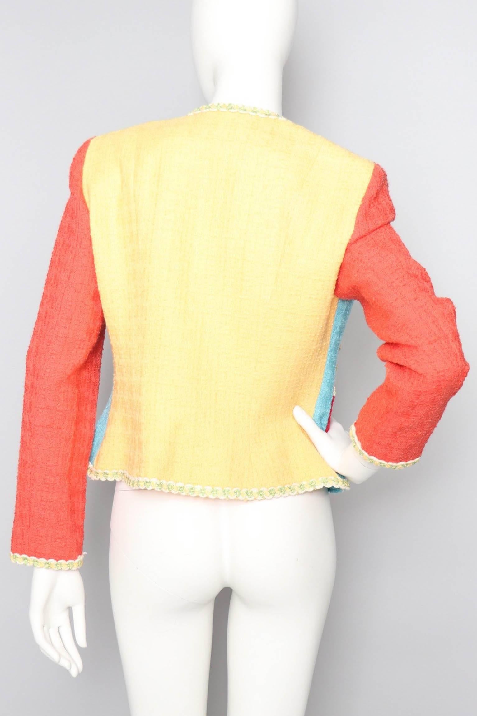 An incredibly fun 1990s Cheap & Chic by Moschino short wool blazer with multi-colored panels and contrasting trim. The jacket is perfect for spring with its open front and delicate lining. The back of the blazer is all yellow, while the front is