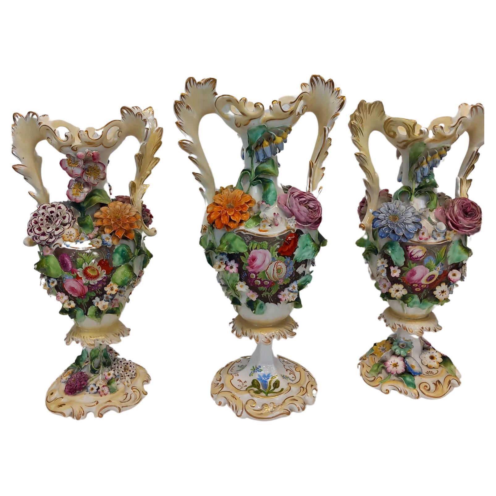 A garniture of three antique English porcelain vases, heavily decorated  For Sale