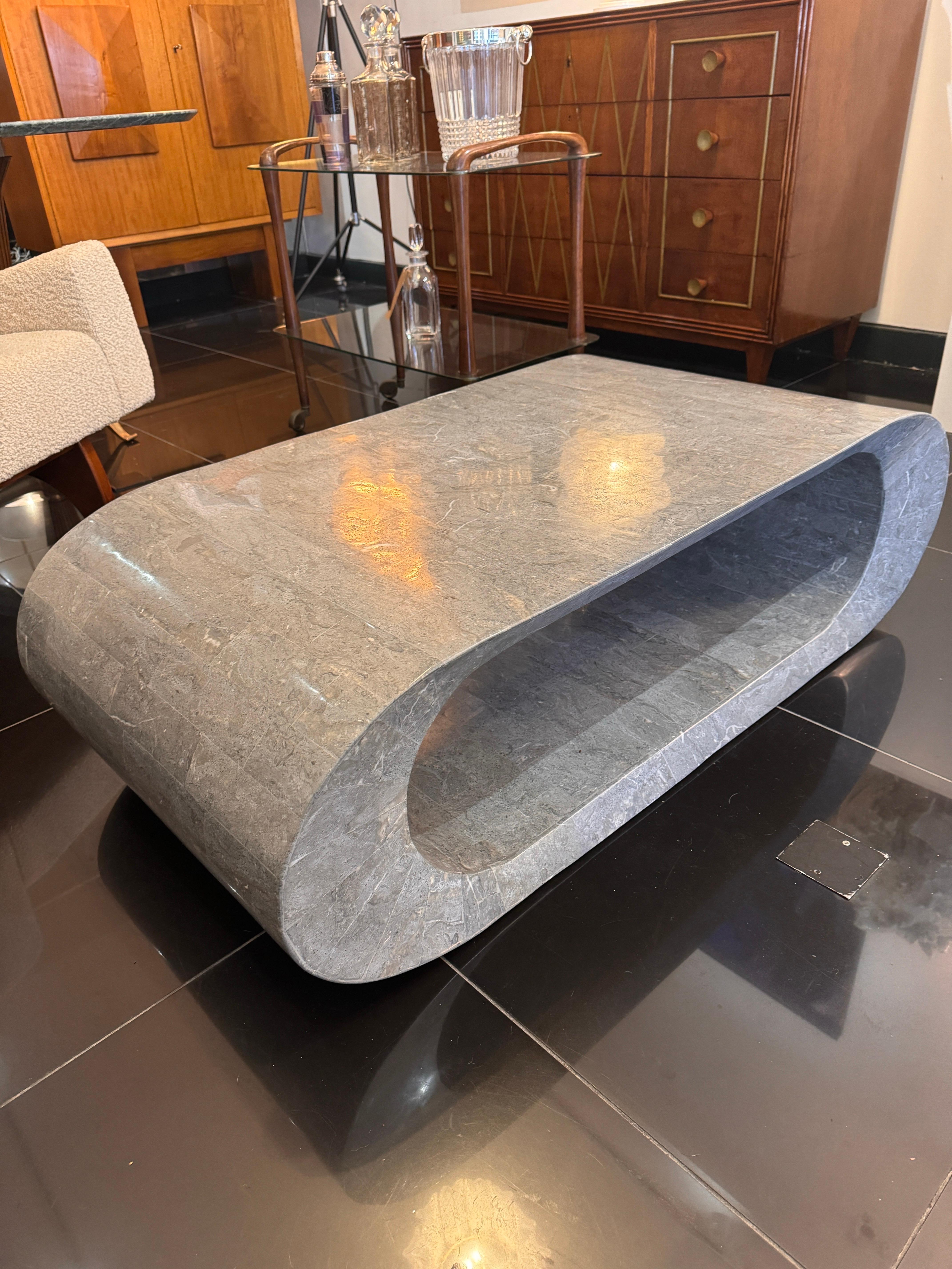 A postmodern geometric design two tiered coffee table in tessellated light grey marble . 
C1980 
Italy 