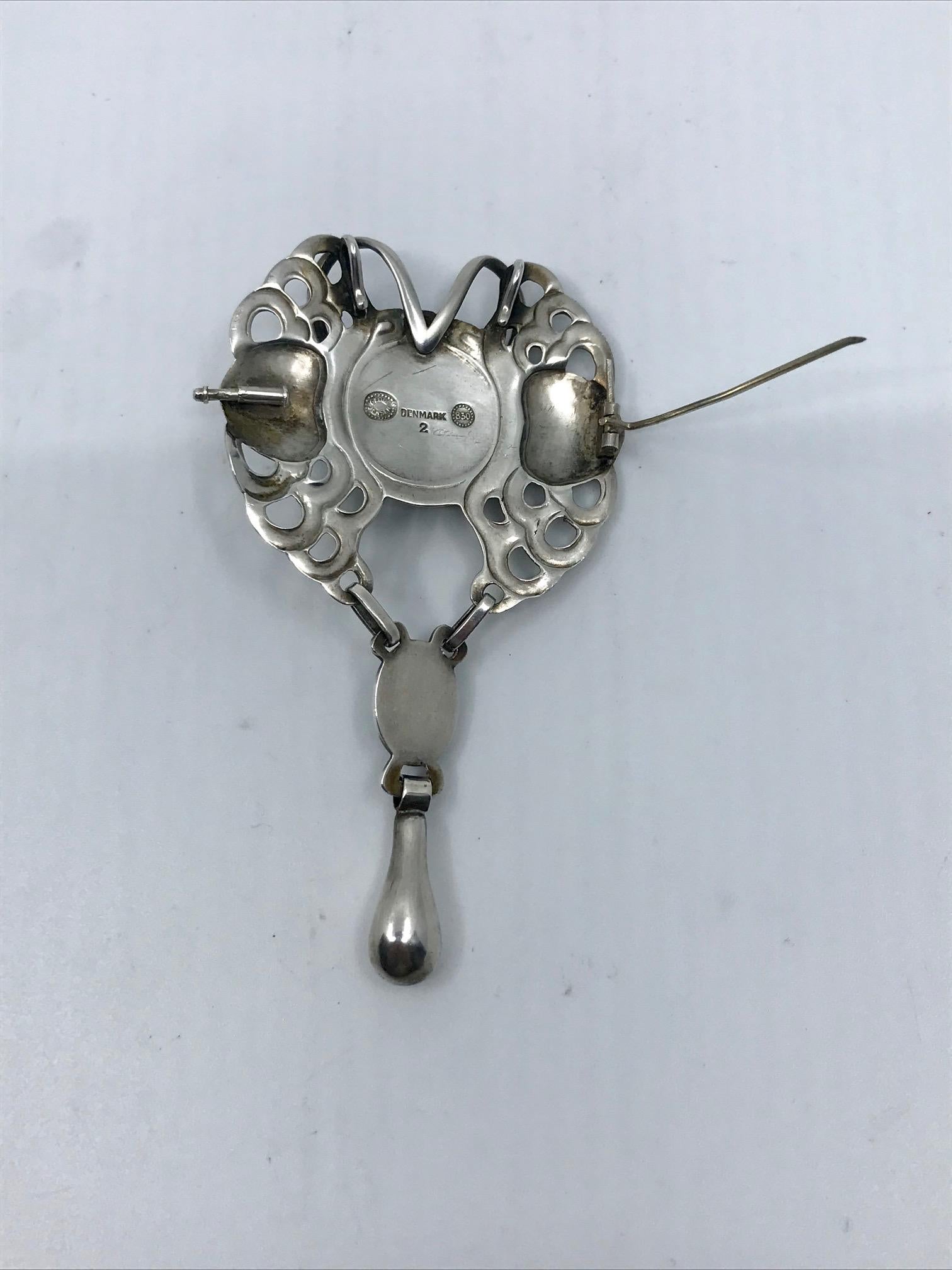 Vintage silver Georg Jensen brooch with a large round and a smaller oval cabochon set labradorite and a silver drop, design #2 by Georg Jensen.
Measures 3 5/8″ x 2″ (9.2cm x 5.1cm). Two eyelets have been very neatly added on the back top of the