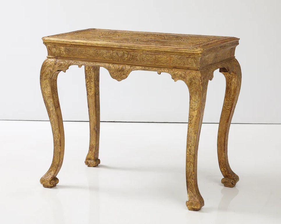 A fine and rare carved gesso console table circa 1720 having a molded and floral carved gesso top resting on a shaped apron having floral carved cabriole legs terminating in stylized Spanish feet. Restoration to the gilding, the top restored with