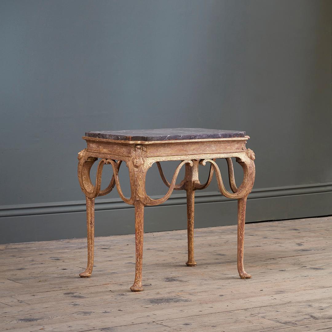 Of modest stature, carved in the round for use as centre, side, or occasional table. With shaped fleur de peche marble top.