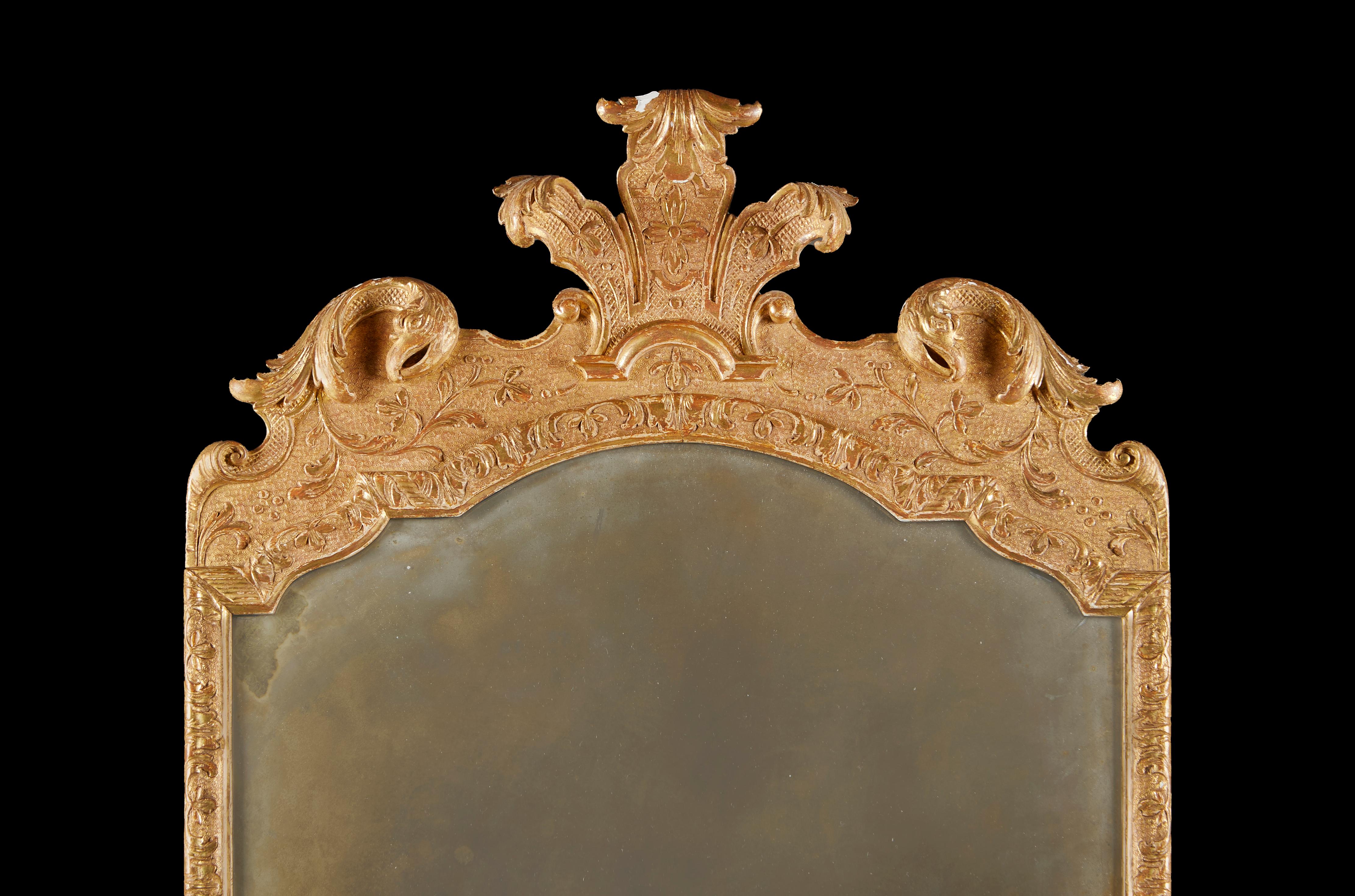 Eine frühe 18. Jahrhundert vergoldet Pier Glas mit fein geschnitzten Wappen, gestanzte Dekoration auf den Rahmen, die ursprüngliche Quecksilber Spiegelplatte zu halten.