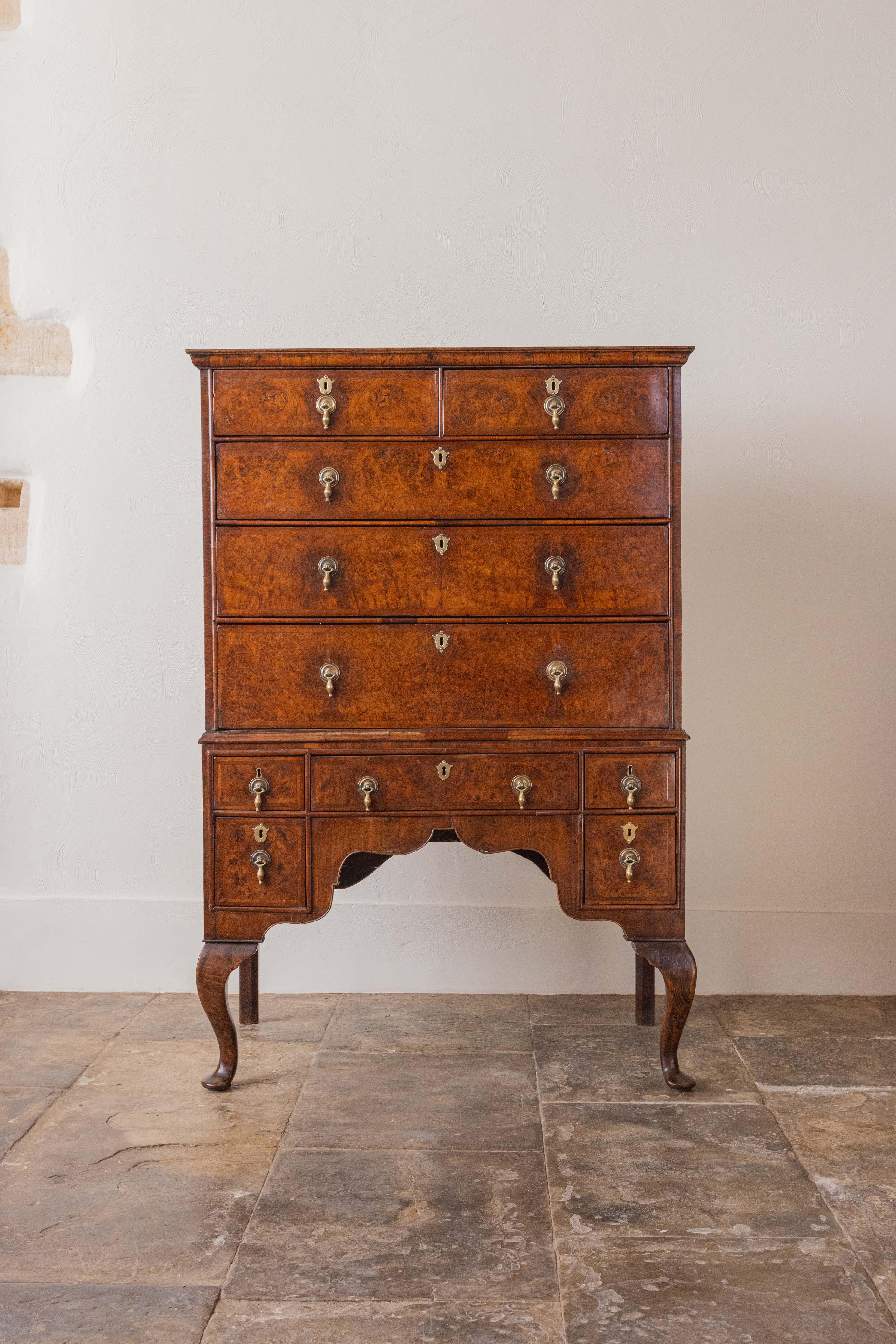 A superb early Georgian tallboy or chest on stand with key, dating from early 1700s. The upper section has two short drawers over three long graduated drawers, all feather-banded and veneered in book matched burr walnut. The lower section with five