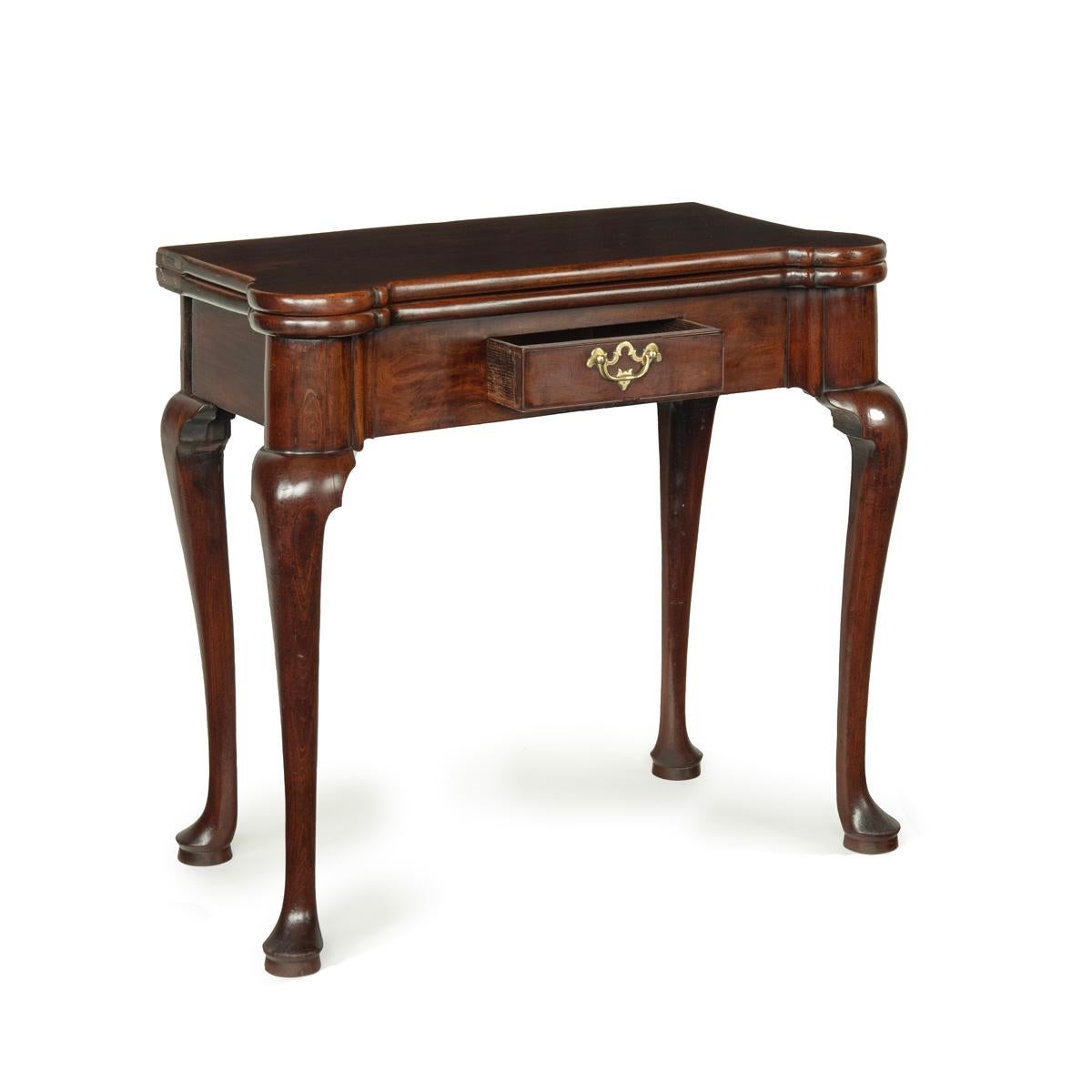 A George I walnut card table, the hinged shaped top above a single small frieze drawer and raised on cabriole legs which terminate in pad feet.  English, circa 1720.
