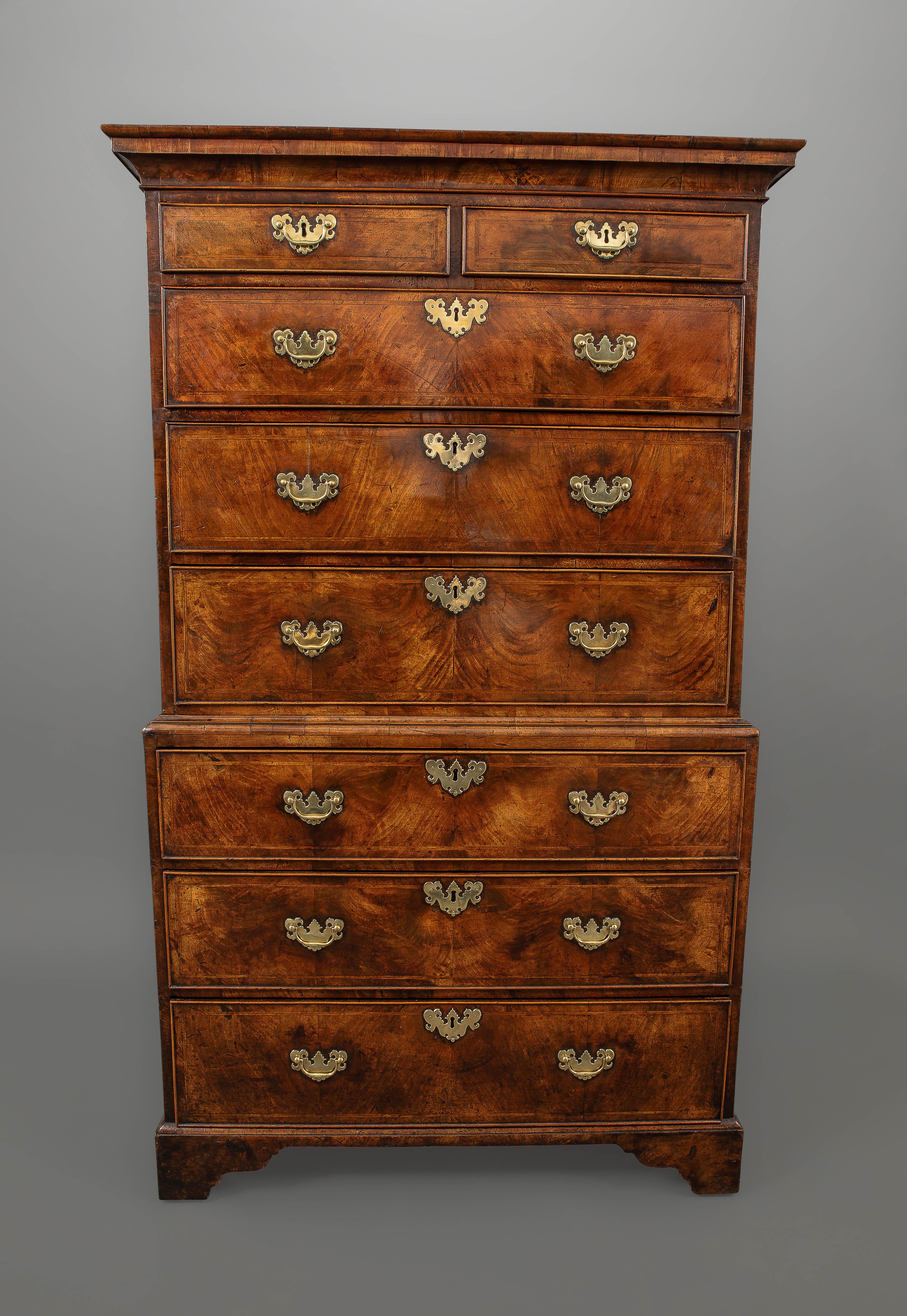 A very desirable walnut chest on chest retaining a very fine color and patina with two short and three long drawers to the top and three long drawers to the base above shaped bracket feet all with the original locks, handles and escutcheons.
The