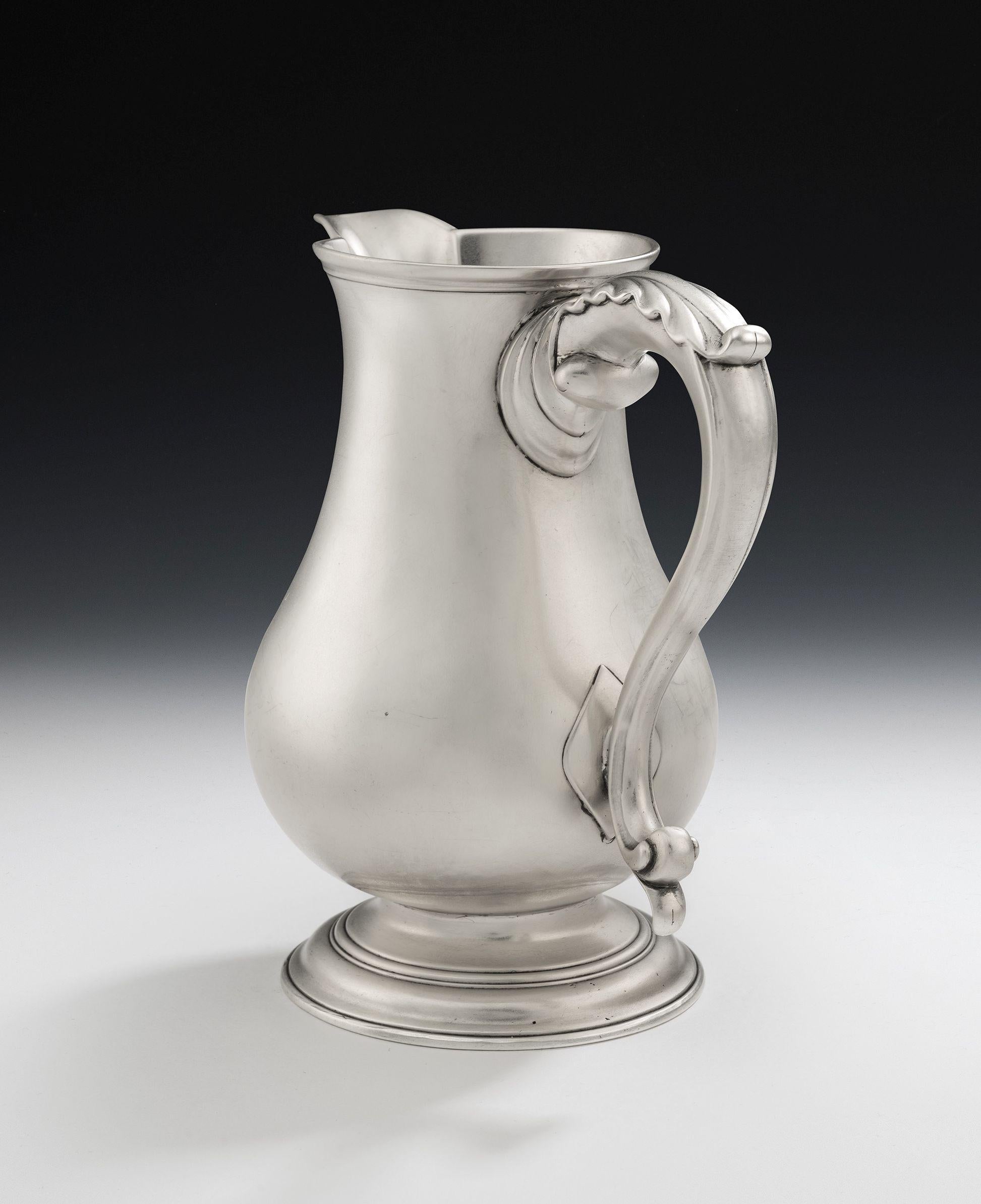 This extremely fine George II antique, sterling silver, Armorial wine/water/beer jug was made in London in 1759 by Robert Albin Cox. The Jug is of an attractive size and stands on a cast and applied spreading foot which is decorated with various