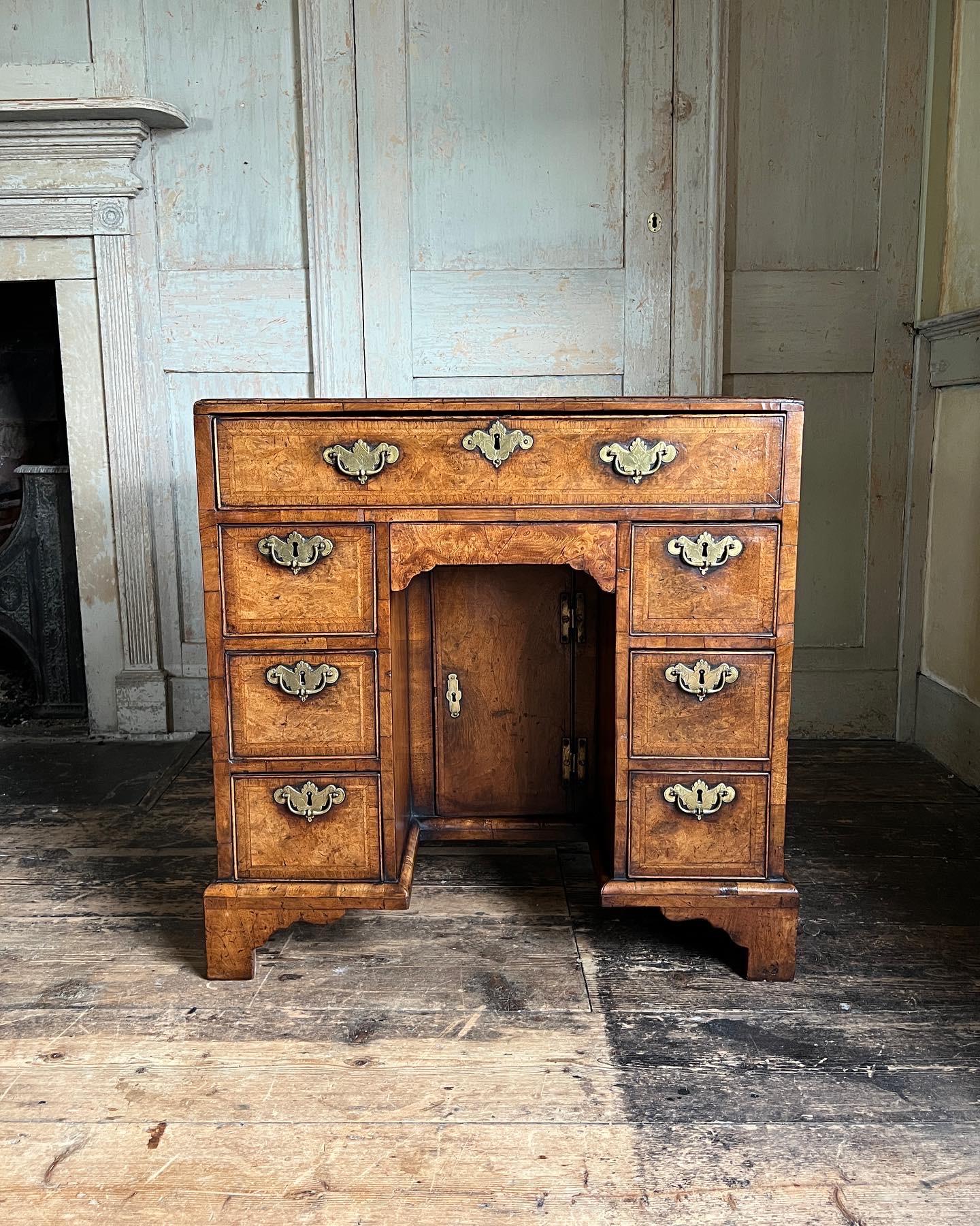 A George II Burr walnut and feather banded kneehole desk with caddy moulded top, c.1735. Of exceptional patina & colour.

Measures - 75cm H x 74cm W x 47cm D.