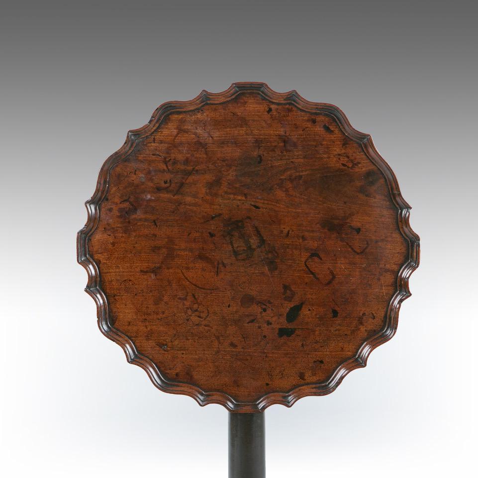 A George II mahogany trypod table, the well figured top with a pie crust edge, resting on a gun barrel stem, with a pad foot. Retaining exceptional color and patina.