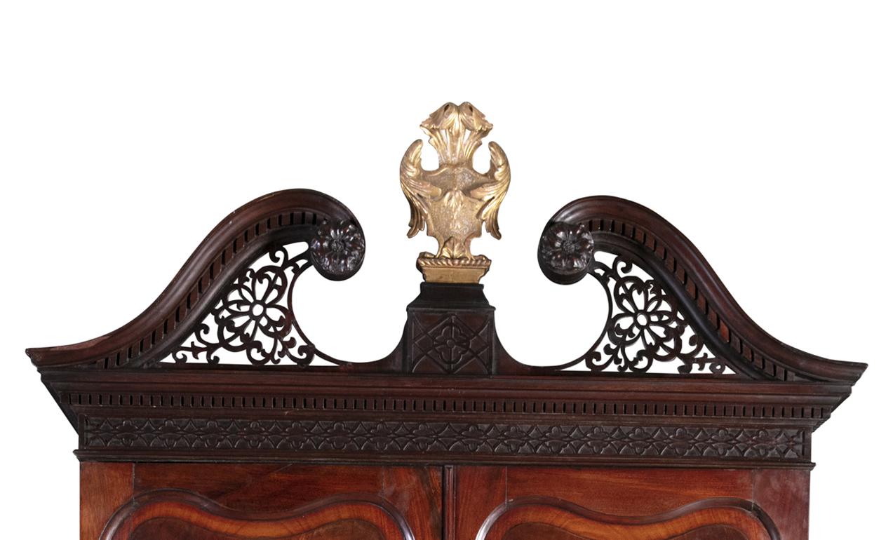 A fine George II Irish mahogany blind door bureau bookcase

The open fret work swan neck cornice outside a carved giltwood Irish cartouche, above two shaped raised panel doors, with a fitted interior, resting on a slope front bureau with a well