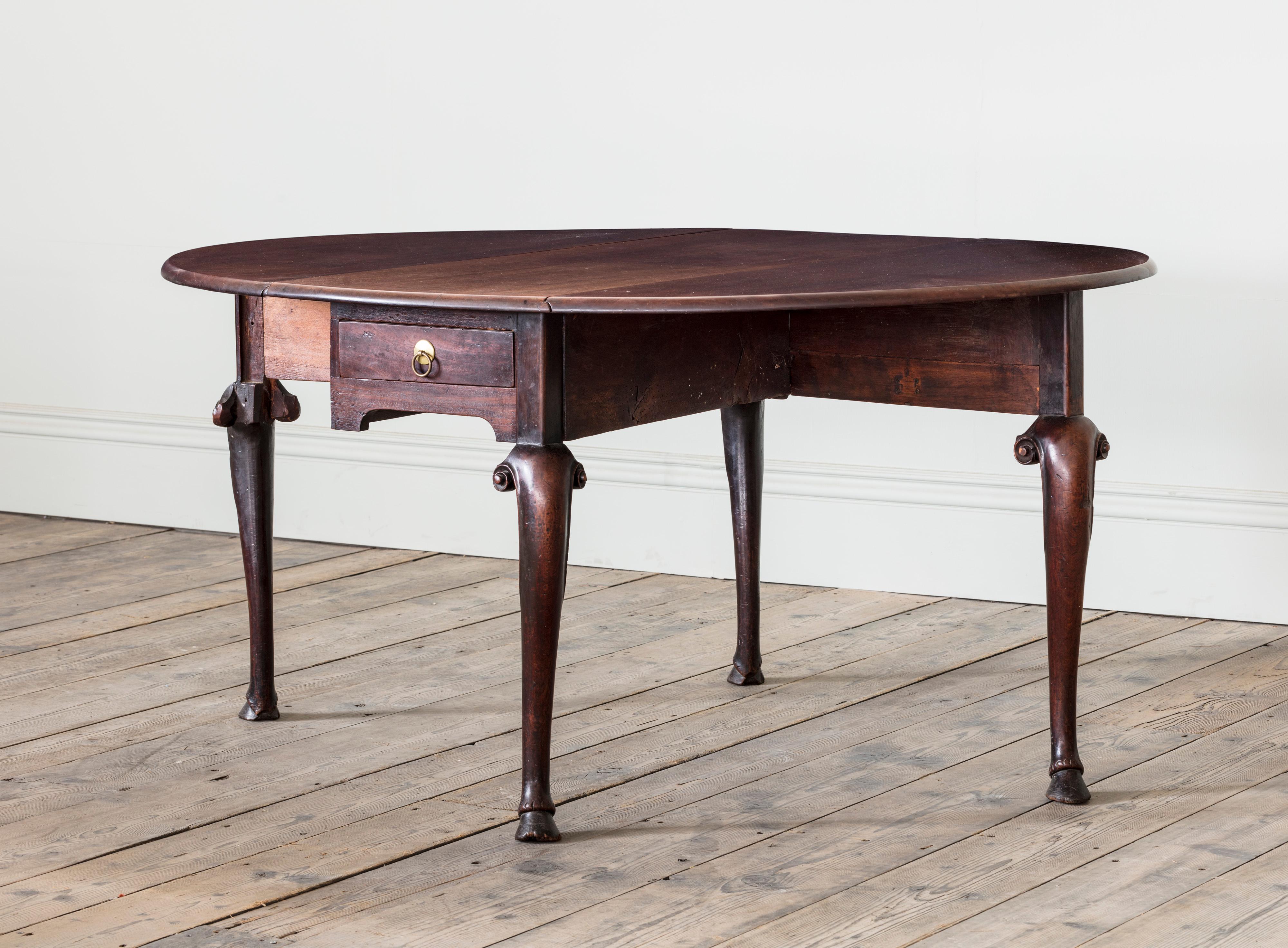 A George II Red Walnut Gateleg Drop Leaf Table
The oval top a rectangular frame with a single drawer,
resting on cabriole legs, with an animalistic carved hoof foot.

English, Circa 1730

Height: 70.5 cm, 27 3/4″
Total Width: 142 cm, 55 7/8″
Width