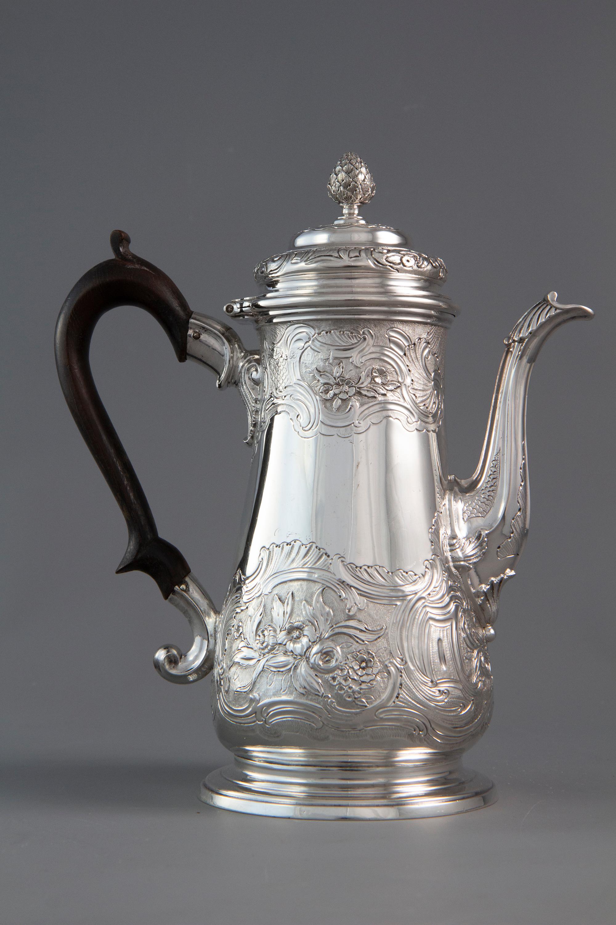 An excellent quality George II silver coffee pot of baluster form. With cast silver leaf capped swan neck spout, stepped domed lid with pine cone finial. The body embossed with floral and foliate decoration. One side with a vacant shaped cartouche.