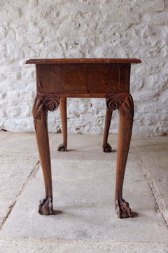 A George II walnut side table with claw feet