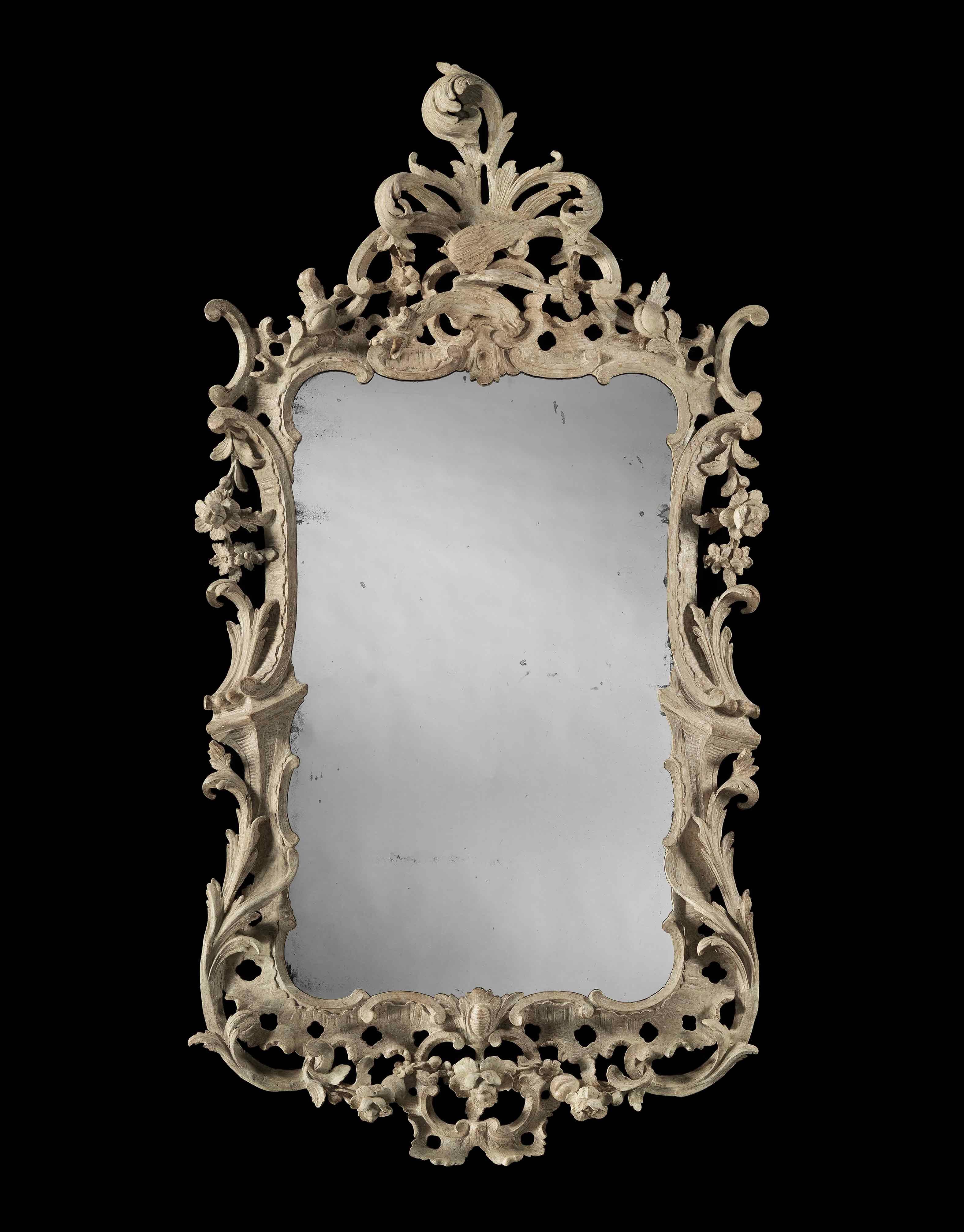 This stunning mirror retains its original paint finish, the cresting with a central carved ho ho bird, perched in front of a spray of flowing acanthus, with c scrolls and carved flowers. The side is decorated with c scrolls, palm leaves, flowers and