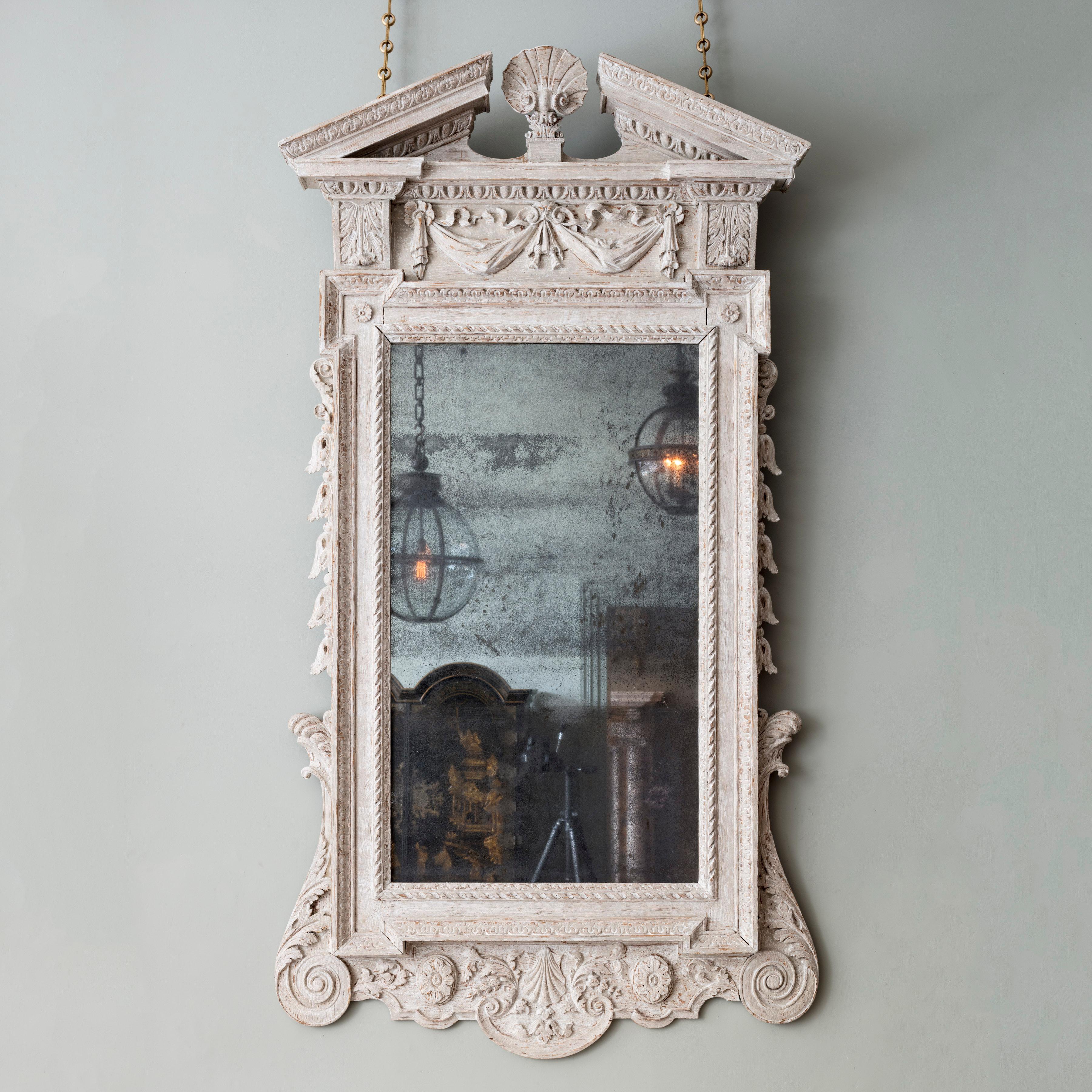 Ein hervorragender irischer weiß bemalter Spiegel aus der Zeit von George II. Der geschnitzte architektonische Aufsatz mit einer zentralen Muschelschale, über einem Paneel mit geschwungenen Bändern und Drapierungen in einer Ei- und Pfeilform,