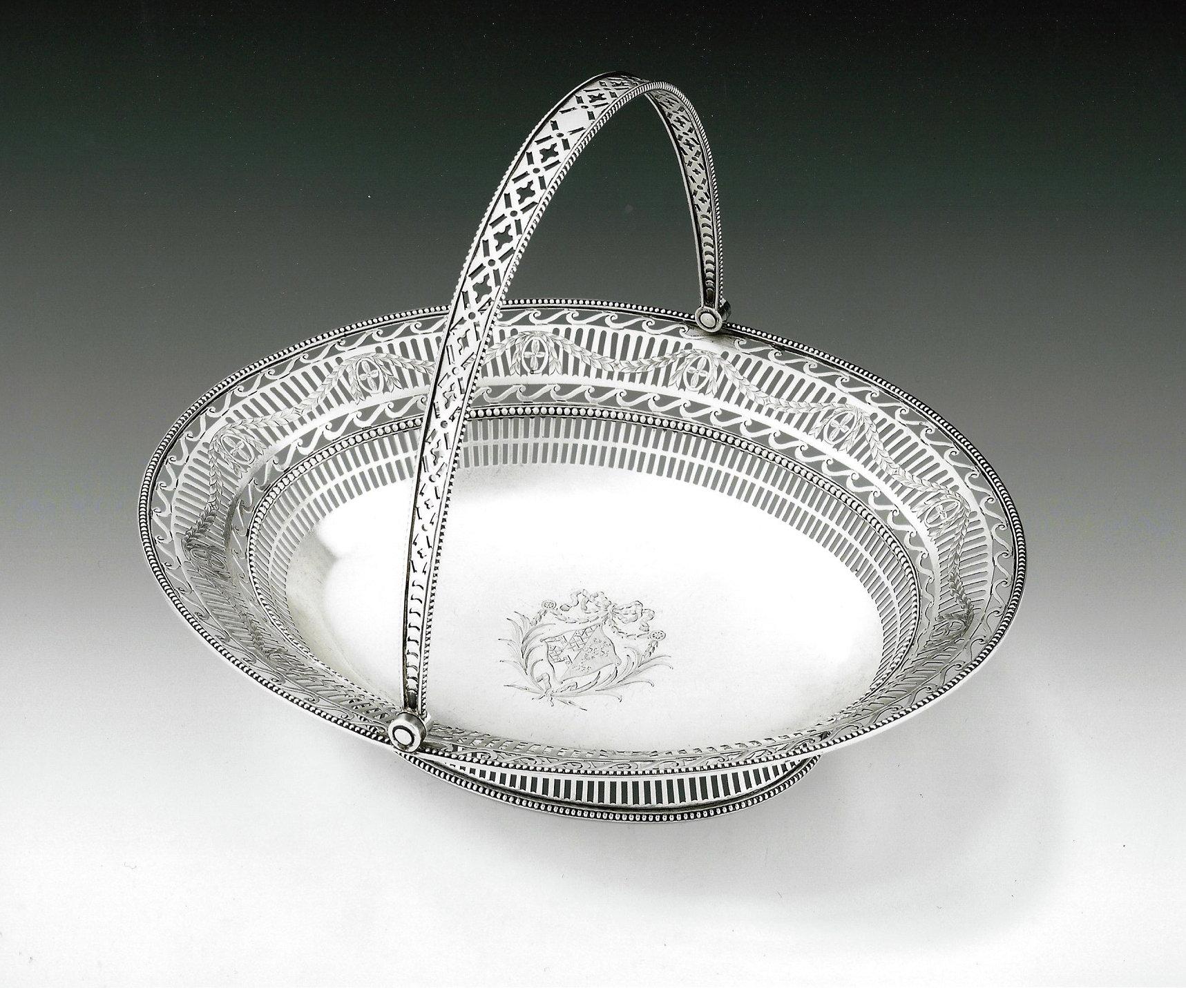 This extremely fine George III neoclassical antique sterling silver bread basket was made in Sheffield in 1777 by Richard Morton & Company. This beautiful basket stands on a flared beaded foot pierced with arched vertical pails. The main body is