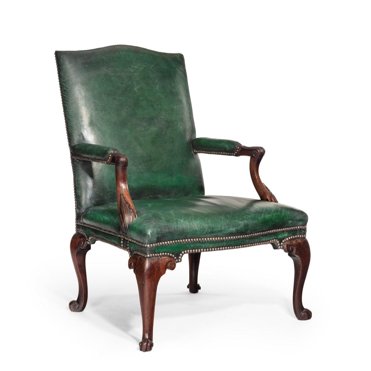 A George III Chippendale period mahogany wing armchair, the shaped back with scrolling arms, the seat rail with pointed knees, all raised on cabriole legs to front and back terminating in a scroll foot, re-upholstered in distressed green leather.
