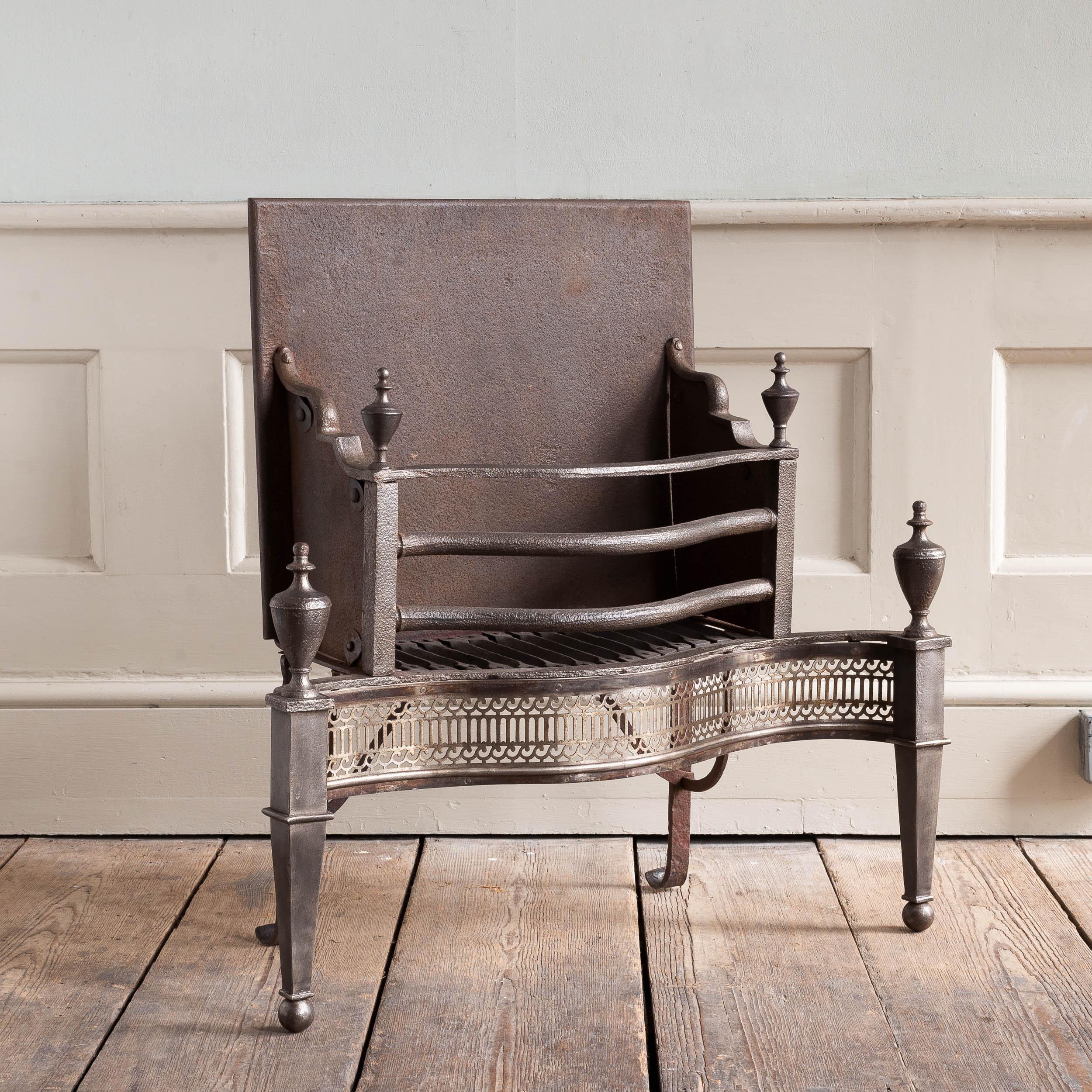 A George III fire grate, iron and steel, with urn finials and serpentine railed basket, the fretwork apron with bands of Vitruvian scrollwork, the tapered standards with ball feet, circa 1780. 


Dimensions:	79cm (31