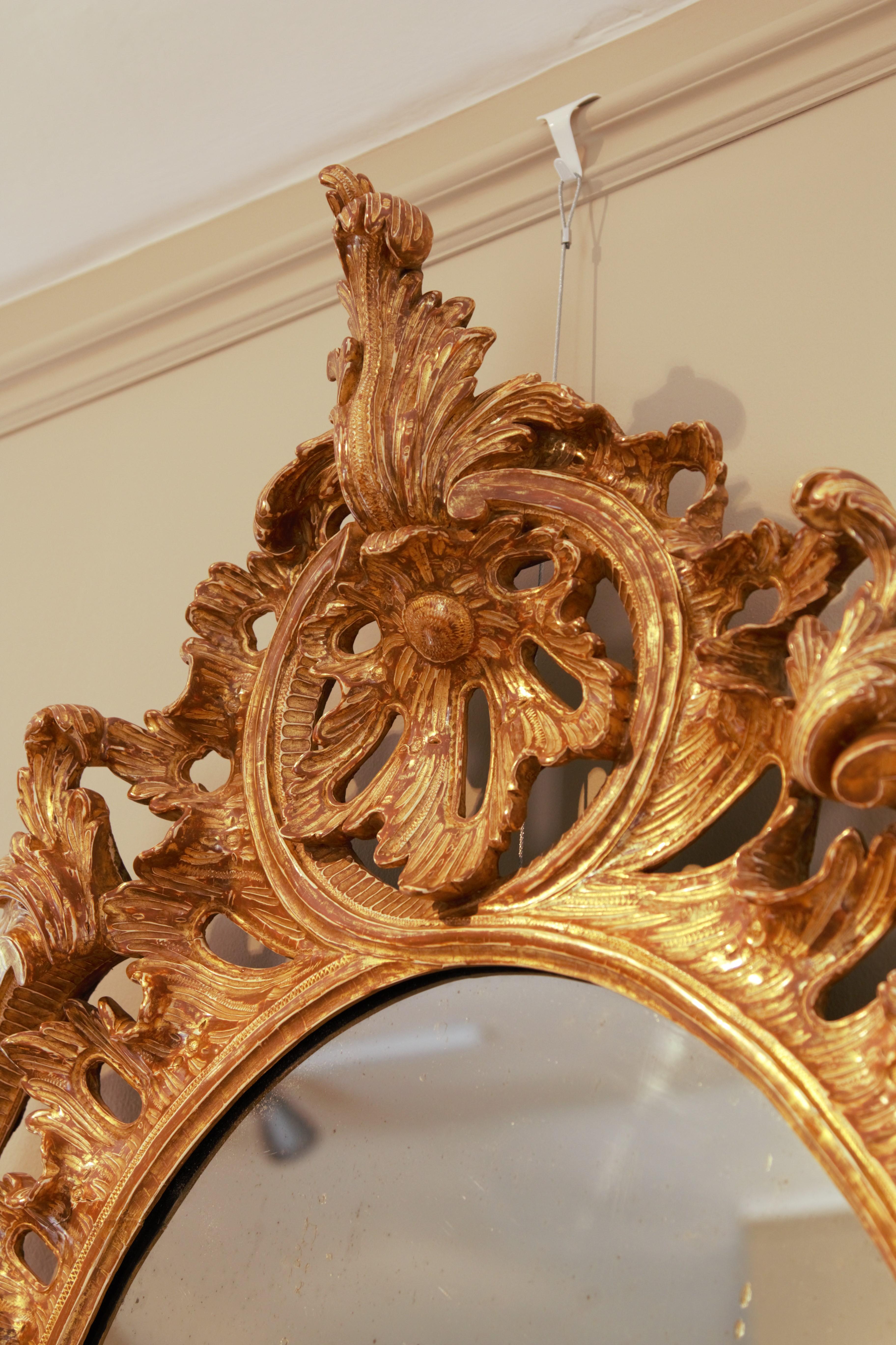 A fine 18th Century rococo wall mirror, the frame with pierced border with C
scrolls and foliate palm and acanthus leaf details.

From the first half of the 18th Century, designs in furniture and interiors
became much more varied and elaborate,