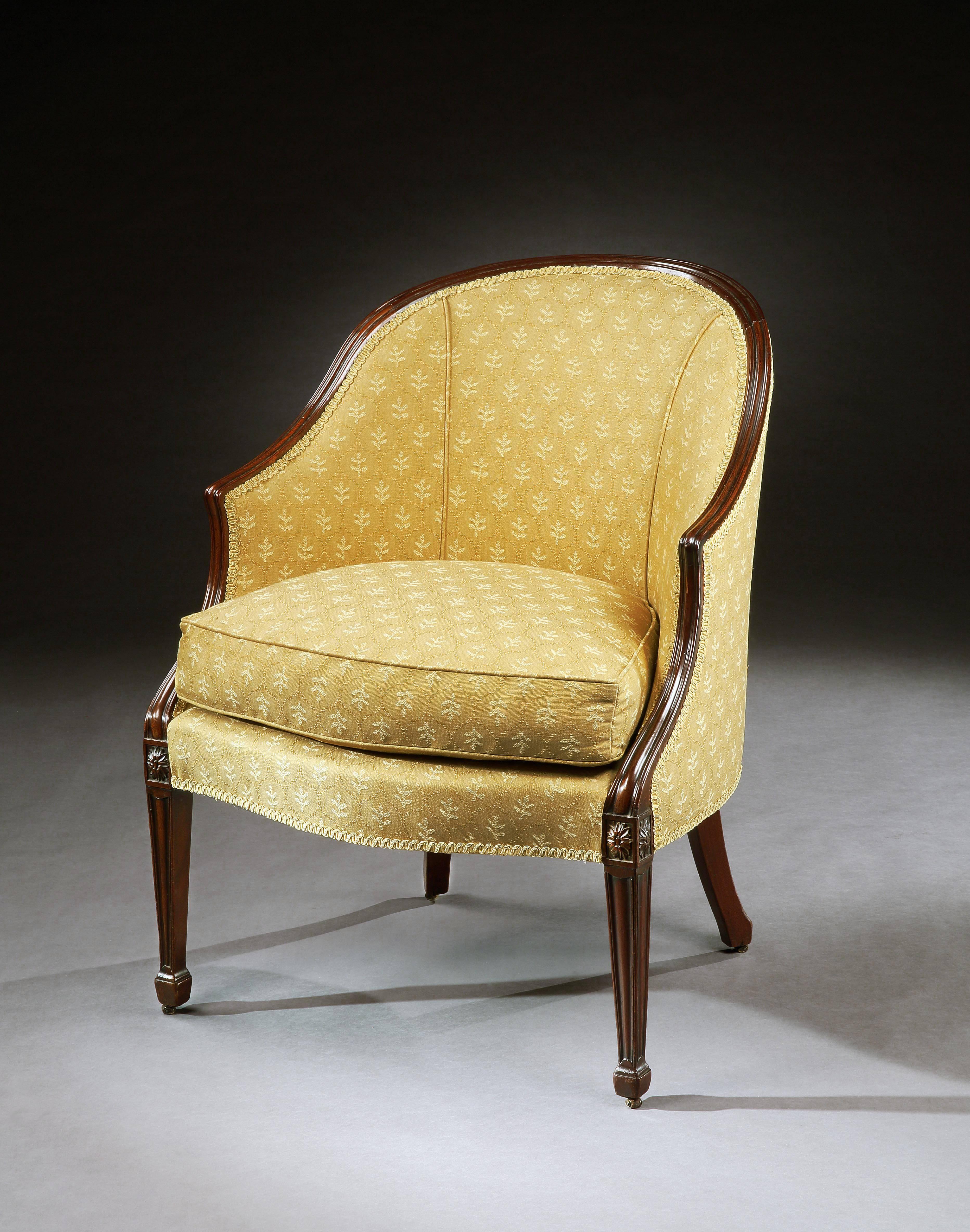 A George III mahogany Bergere chair, the moulded seat frame above splayed rear legs and fluted front legs headed with patara, terminating in its original castors.