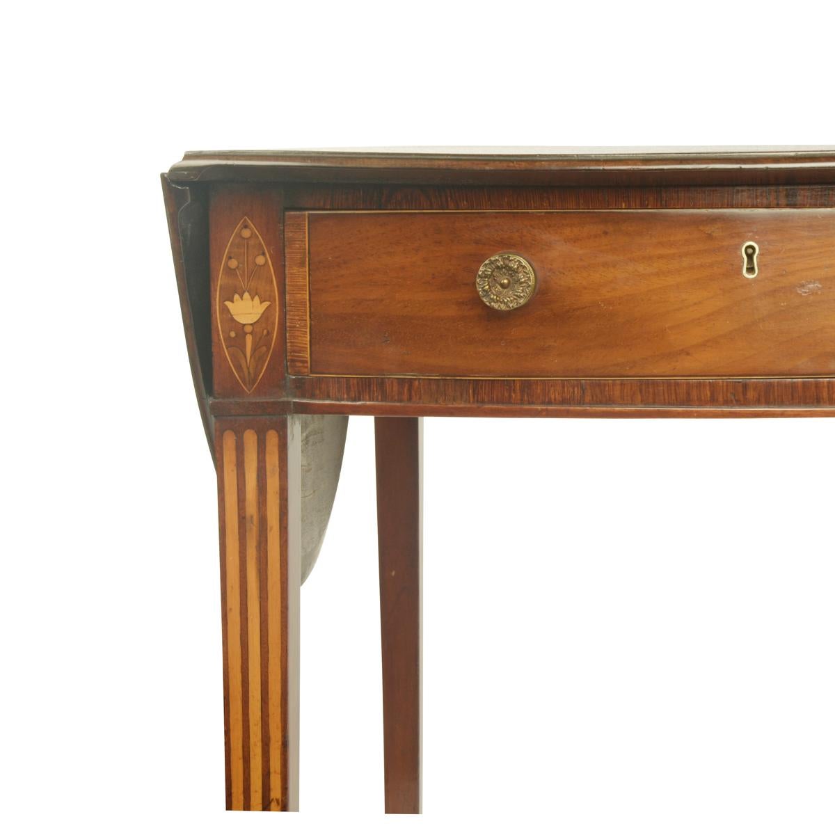 Table Pembroke en acajou de George III, le plateau ovale à deux abattants au-dessus d'un tiroir en frise, décoré de bandes transversales en bois de rose, reposant sur des pieds fuselés de section carrée avec incrustation de buis, le tout reposant