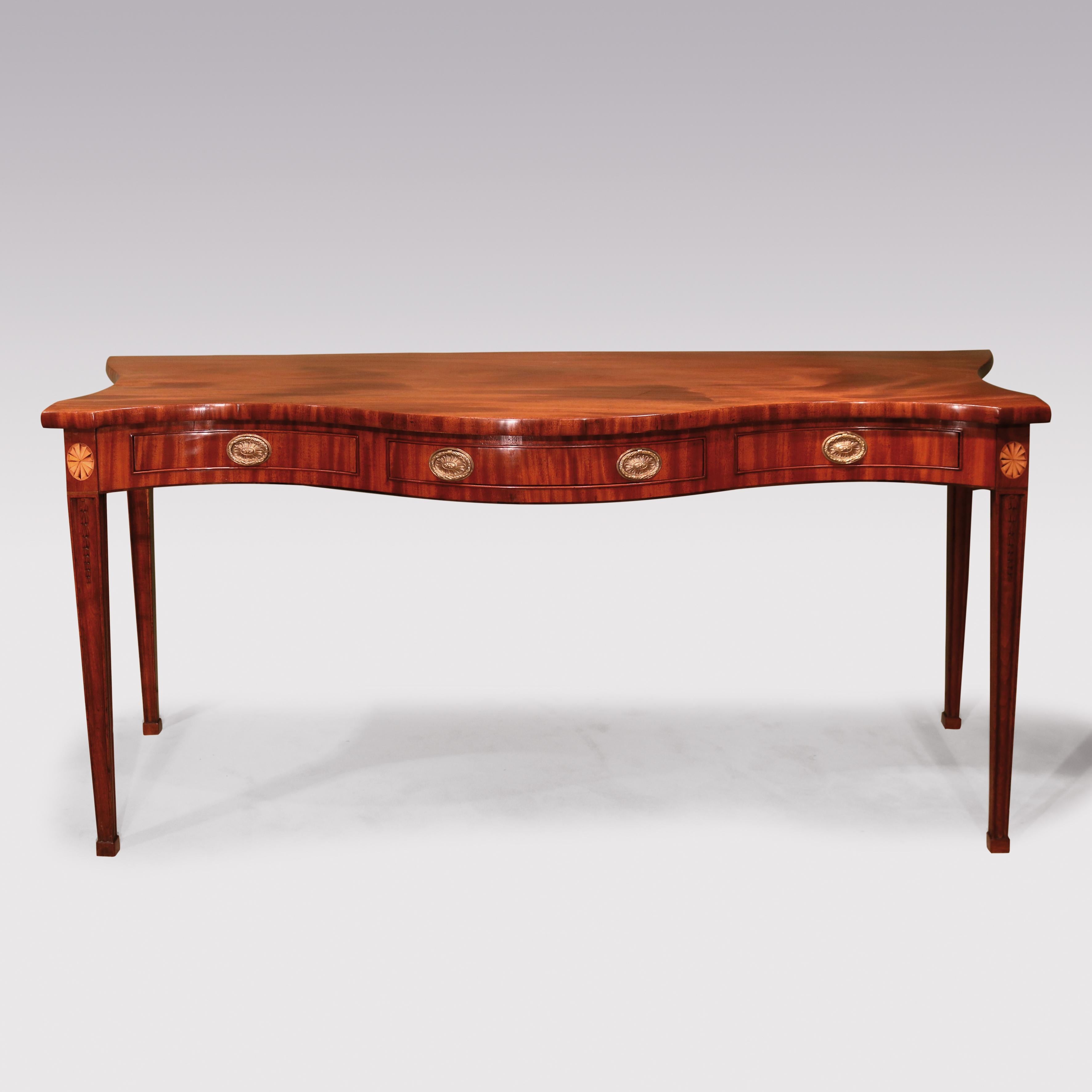 A fine quality late 18th century Sheraton period figured mahogany serving table, having serpentine front and sides with 3 frieze drawers, supported on moulded square tapering legs with boxwood fan inlay and husk carving ending on block feet.
